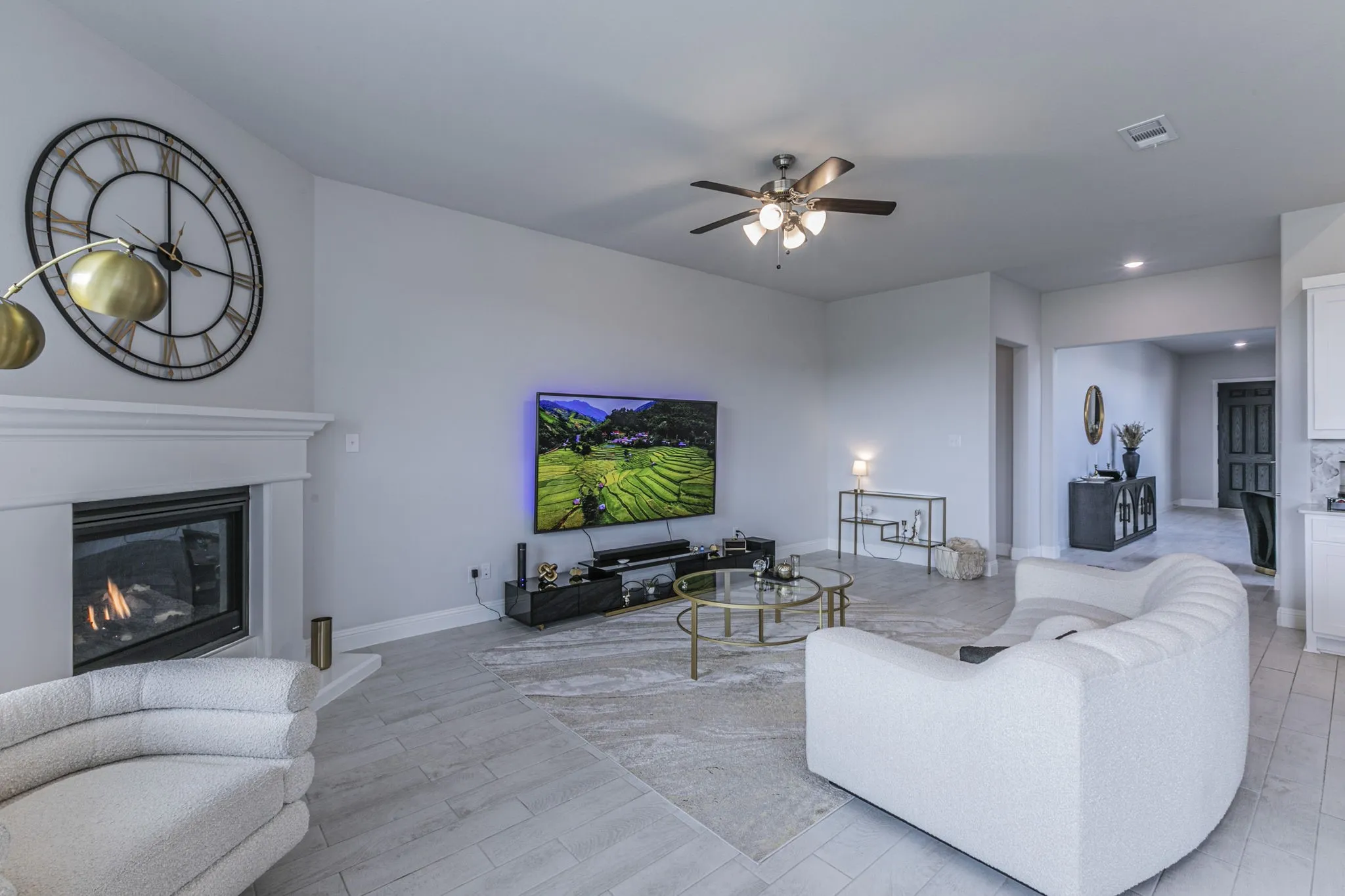Living room with a ceiling fan, a glass covered fireplace, recessed lighting, and light wood finished floors