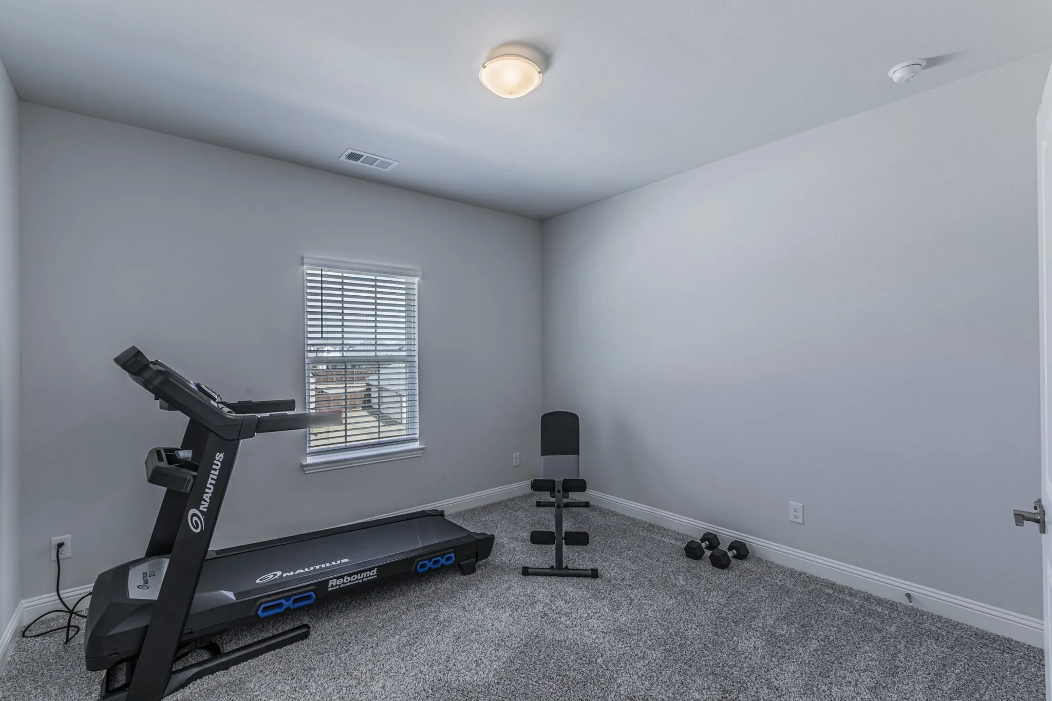 Workout room featuring carpet flooring and baseboards