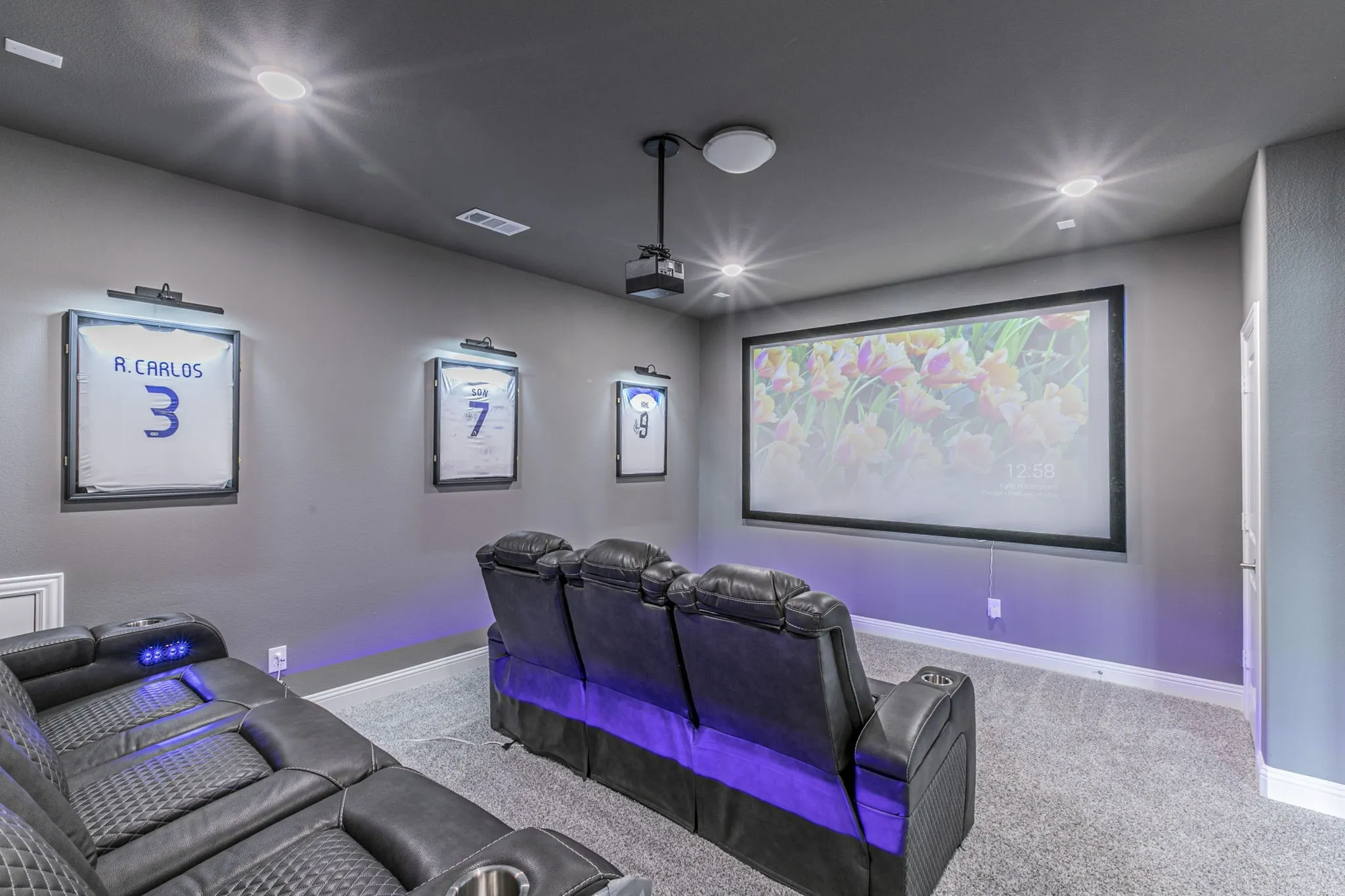 Cinema room with light carpet and recessed lighting
