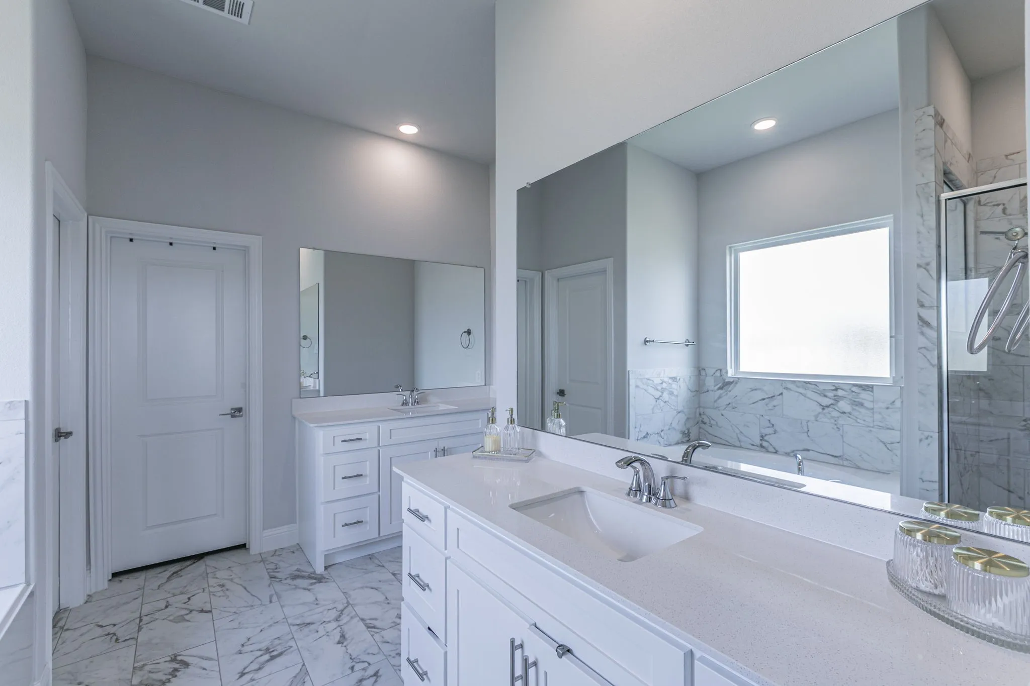 Bathroom with two vanities, light marble finish flooring, a garden tub, and a marble finish shower