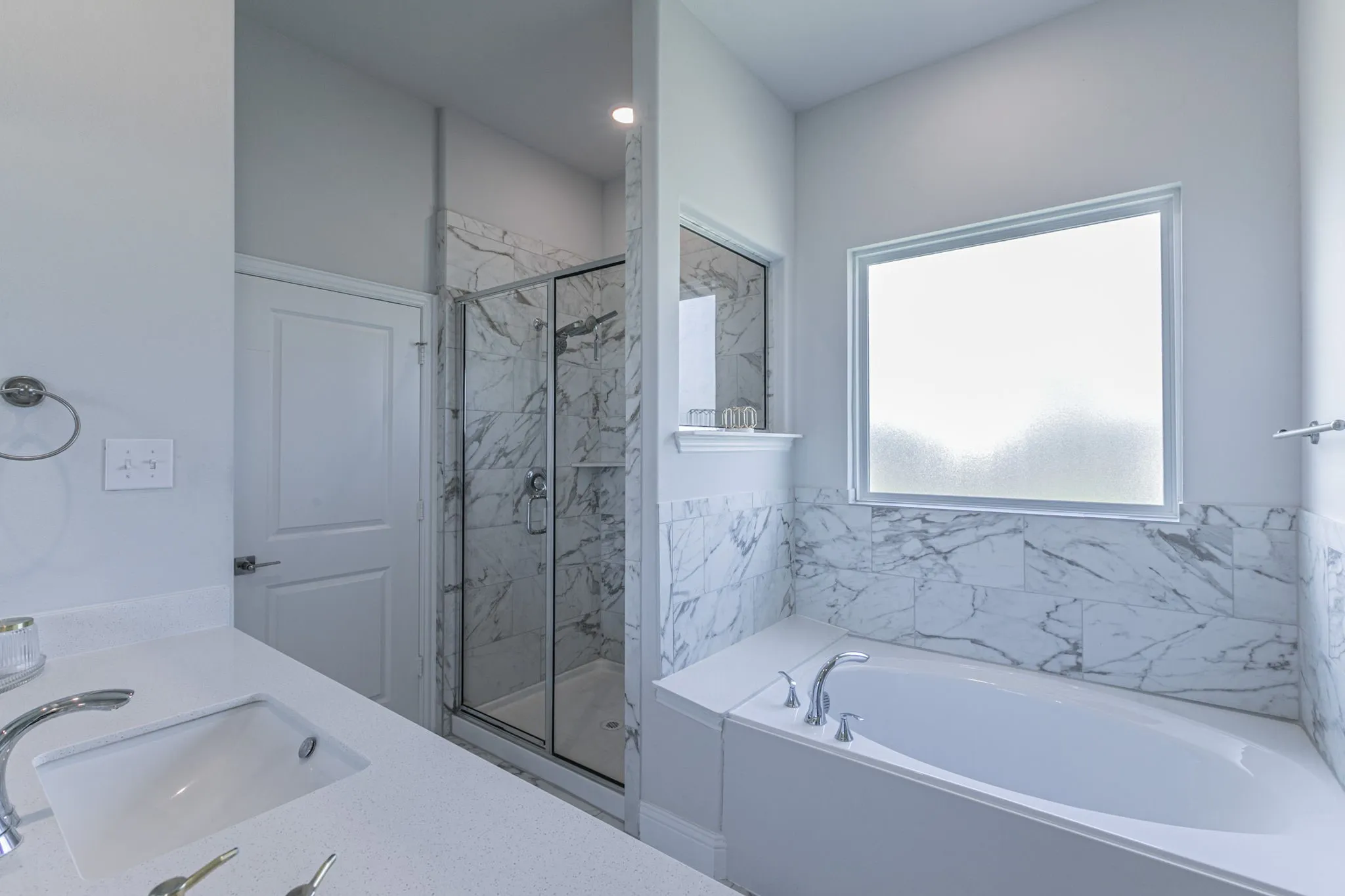 Bathroom with double vanity, a marble finish shower, and a garden tub