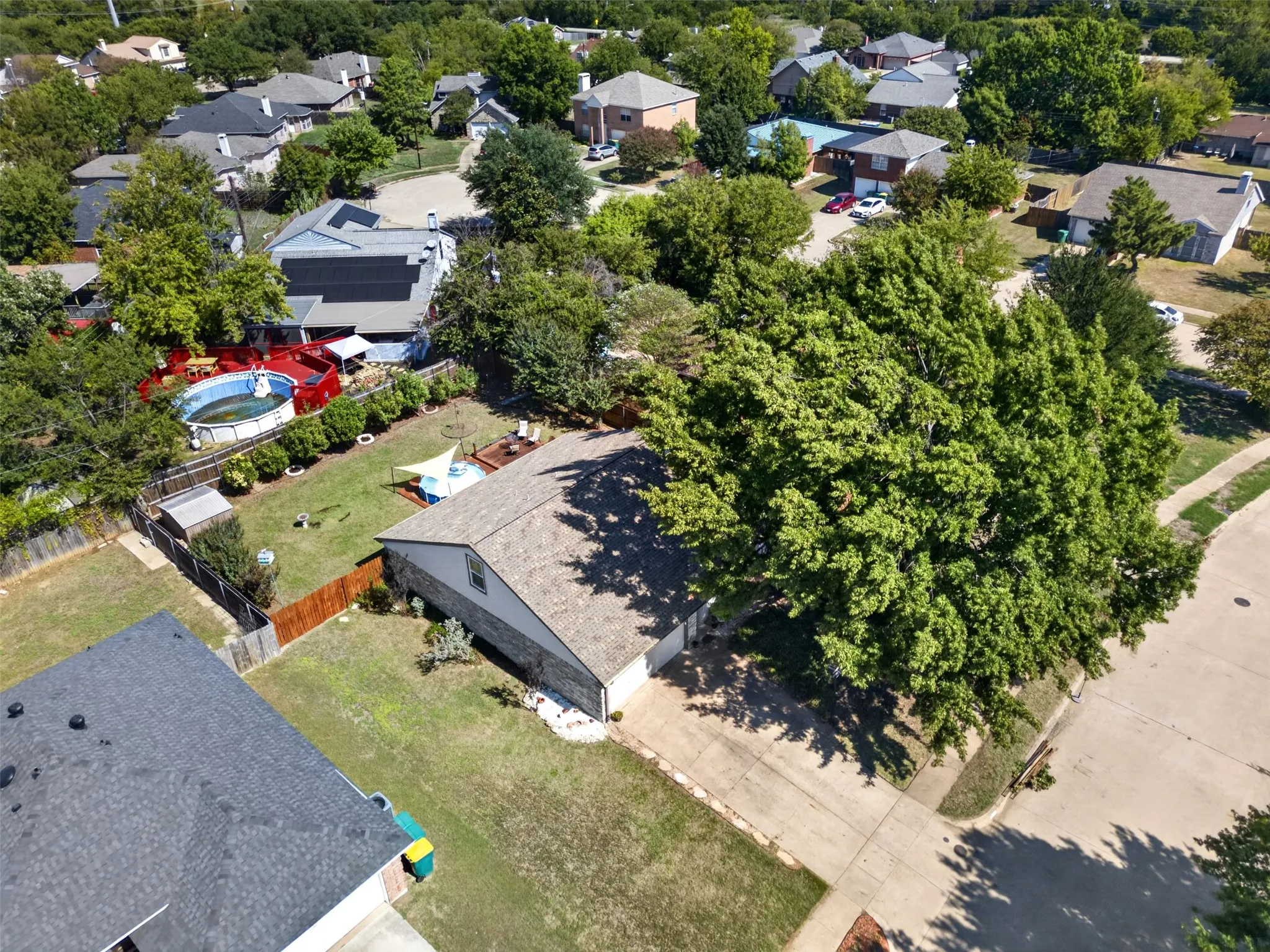 Expansive property featuring a paved driveway, mature trees, and a private fenced yard with an above-ground pool