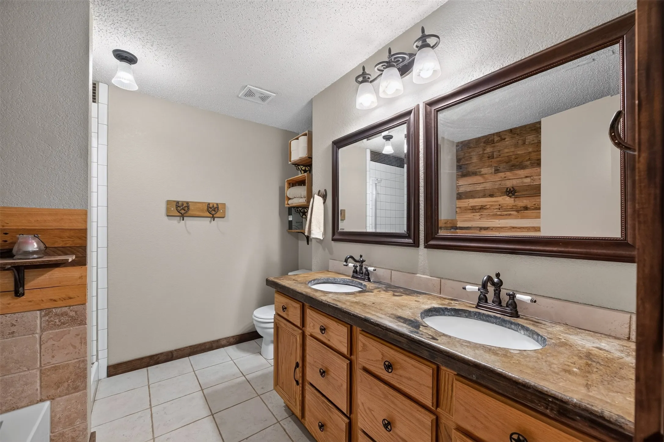 Dual vanity with integrated sinks, wood-finish cabinetry, and framed mirrors