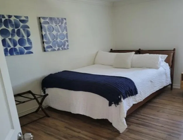 Wood-finish flooring with white walls and crown molding