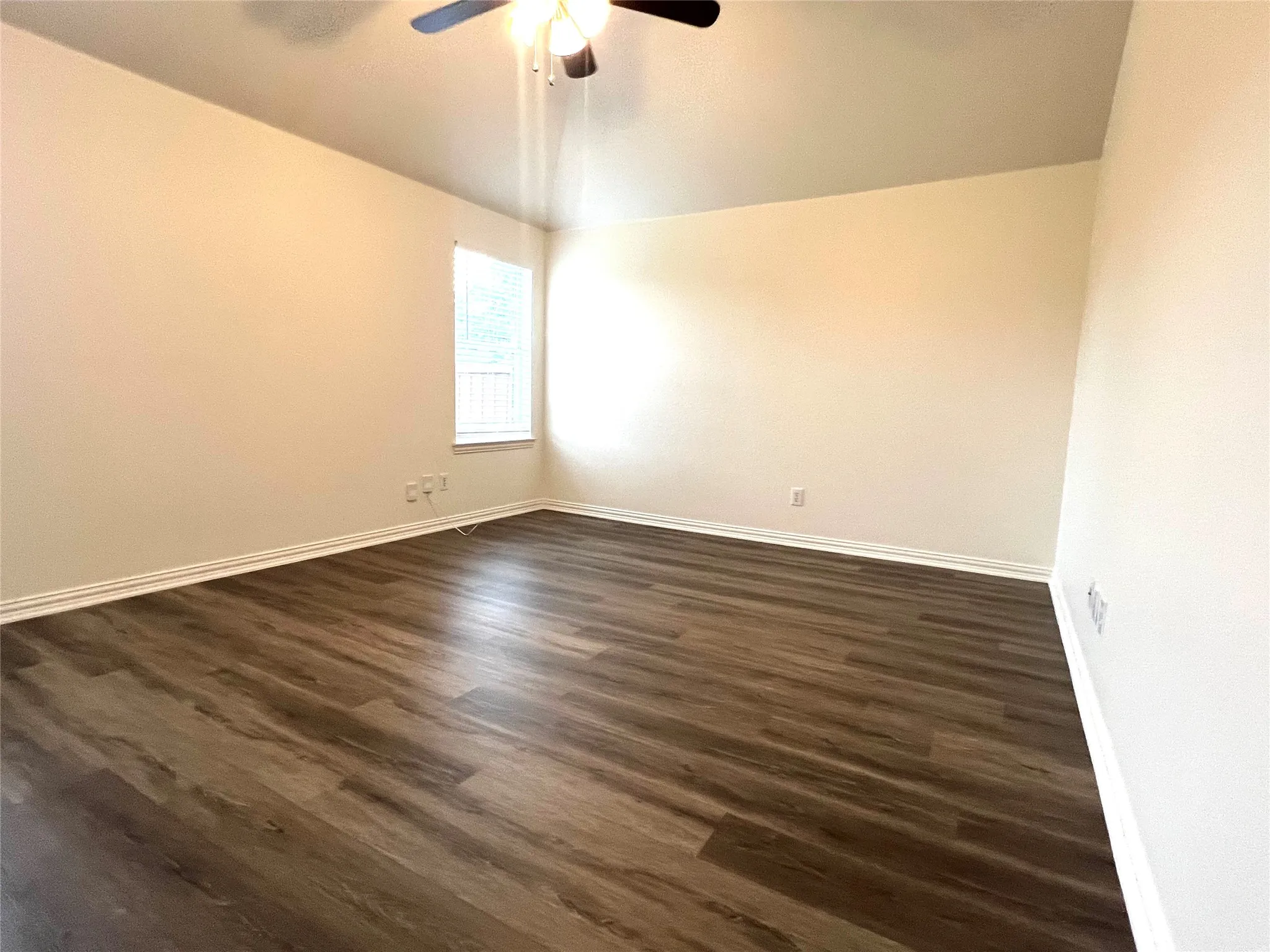 Empty room featuring dark wood-style flooring and lofted ceiling