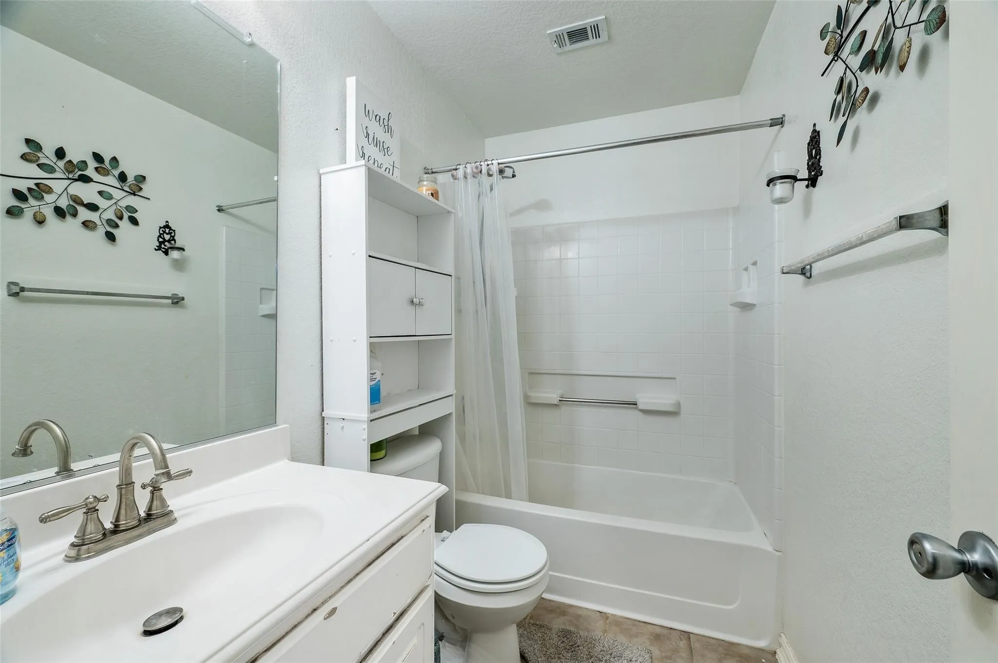 Bathroom with shower / bath combination with curtain, vanity, and tile patterned flooring