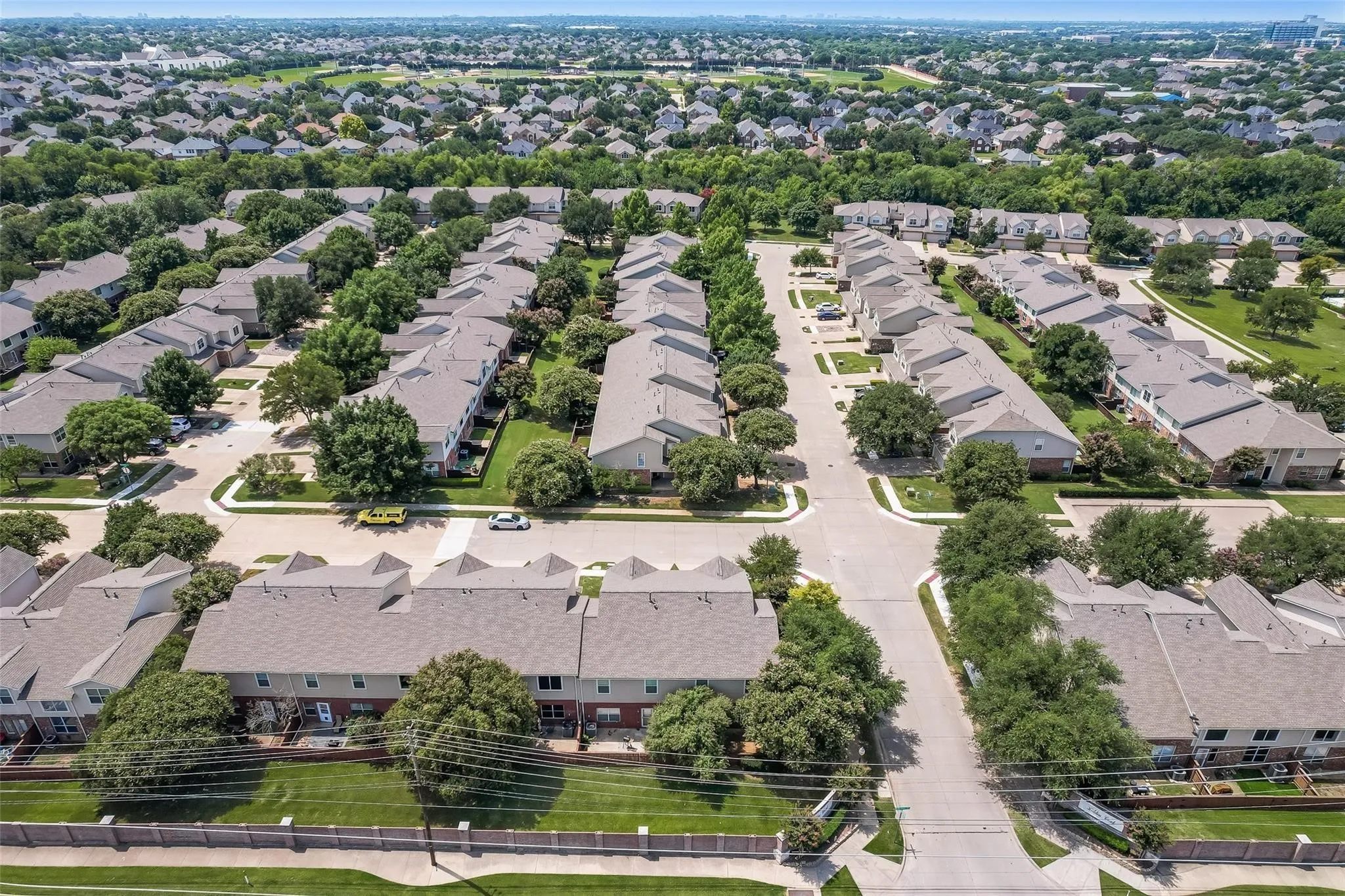Residential community featuring multiple two-story structures, paved roadways, and landscaped grounds