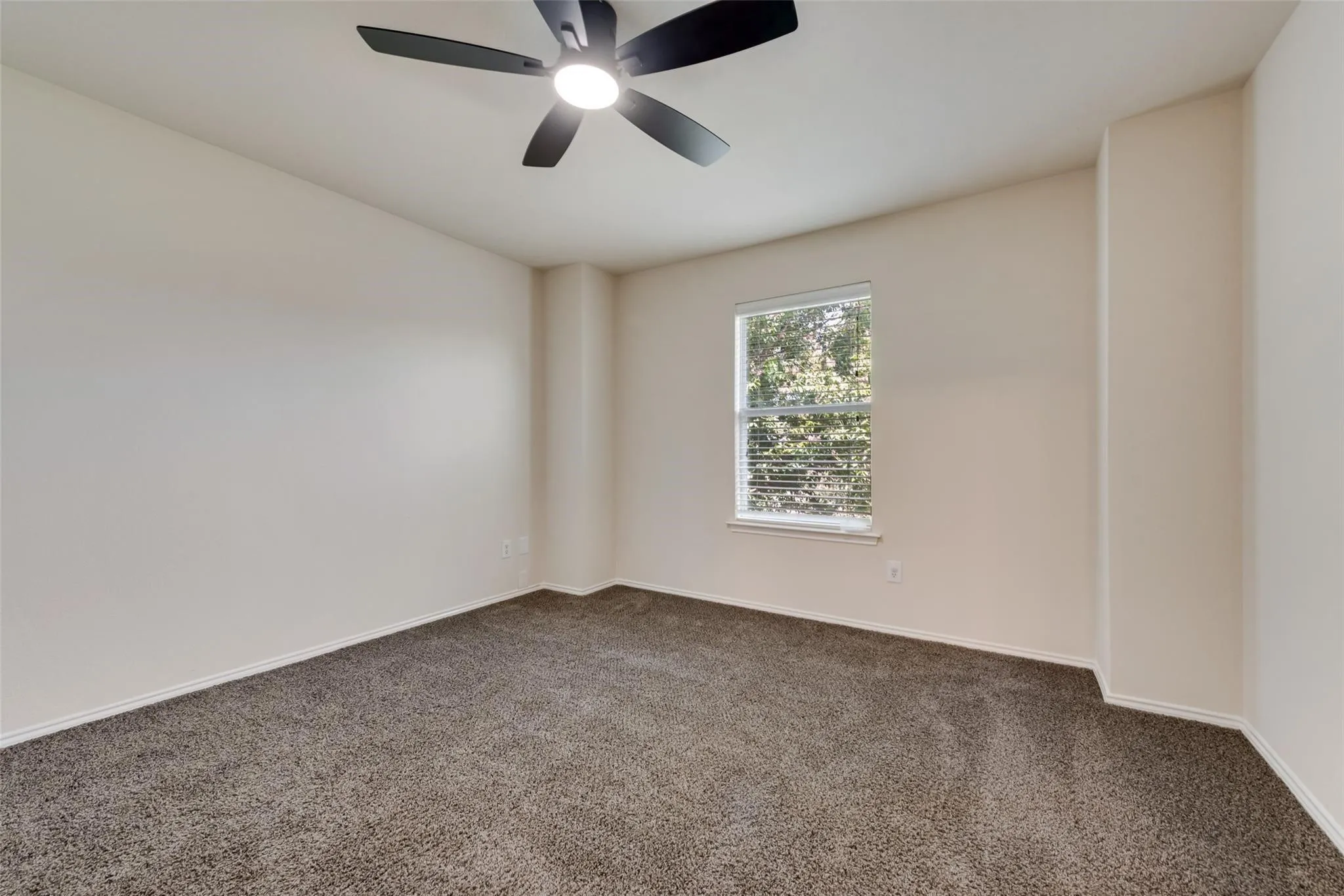 Neutral wall color, ceiling fan with integrated lighting, window with blinds, and carpet flooring