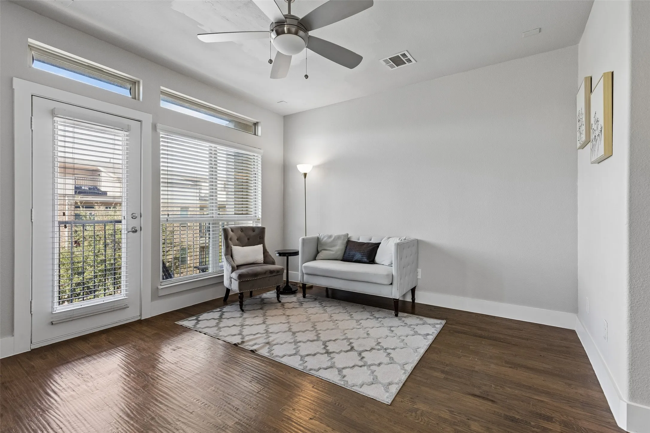 Wood-finish flooring, white walls, and a ceiling fan with integrated lighting