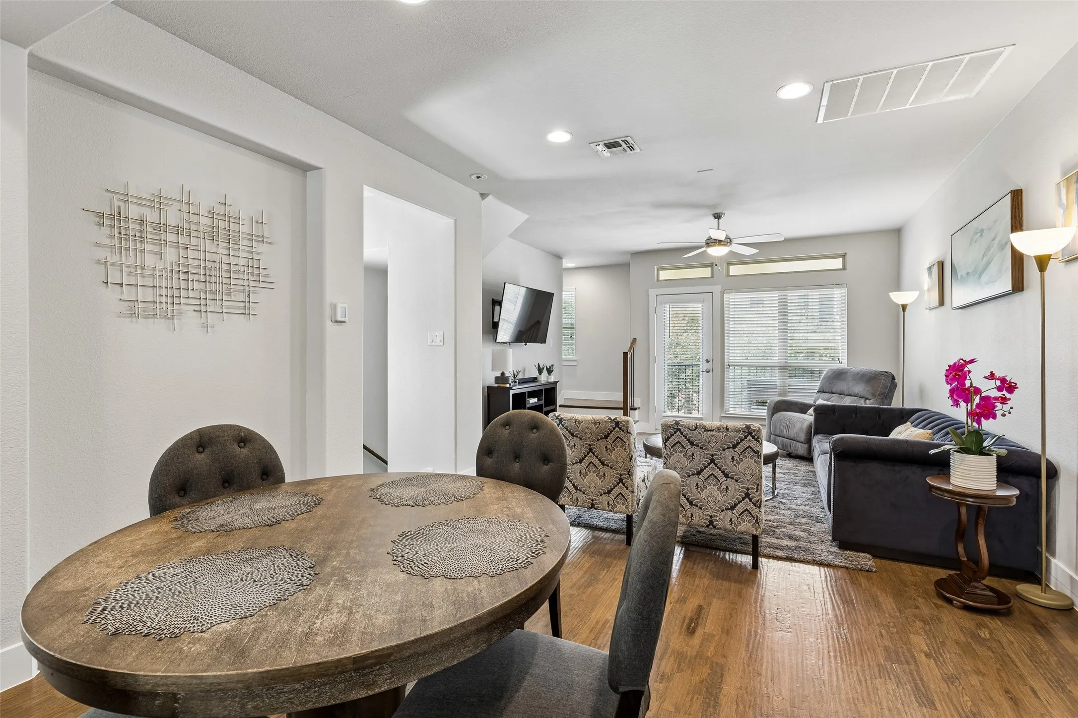 Open-concept living area with wood-finish flooring, recessed lighting, and a ceiling fan