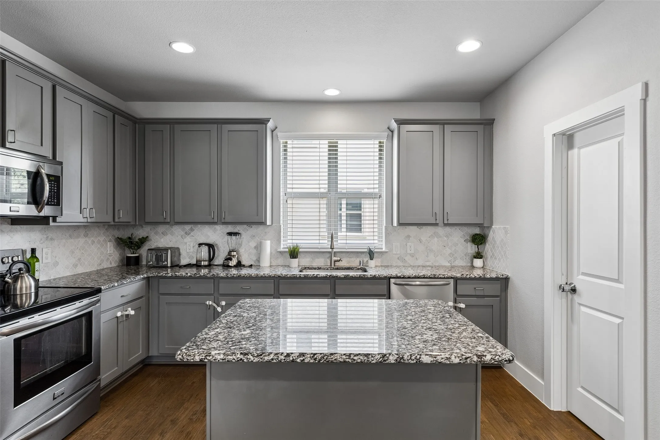 Kitchen featuring wood-finish flooring, recessed lighting, and stainless steel appliances