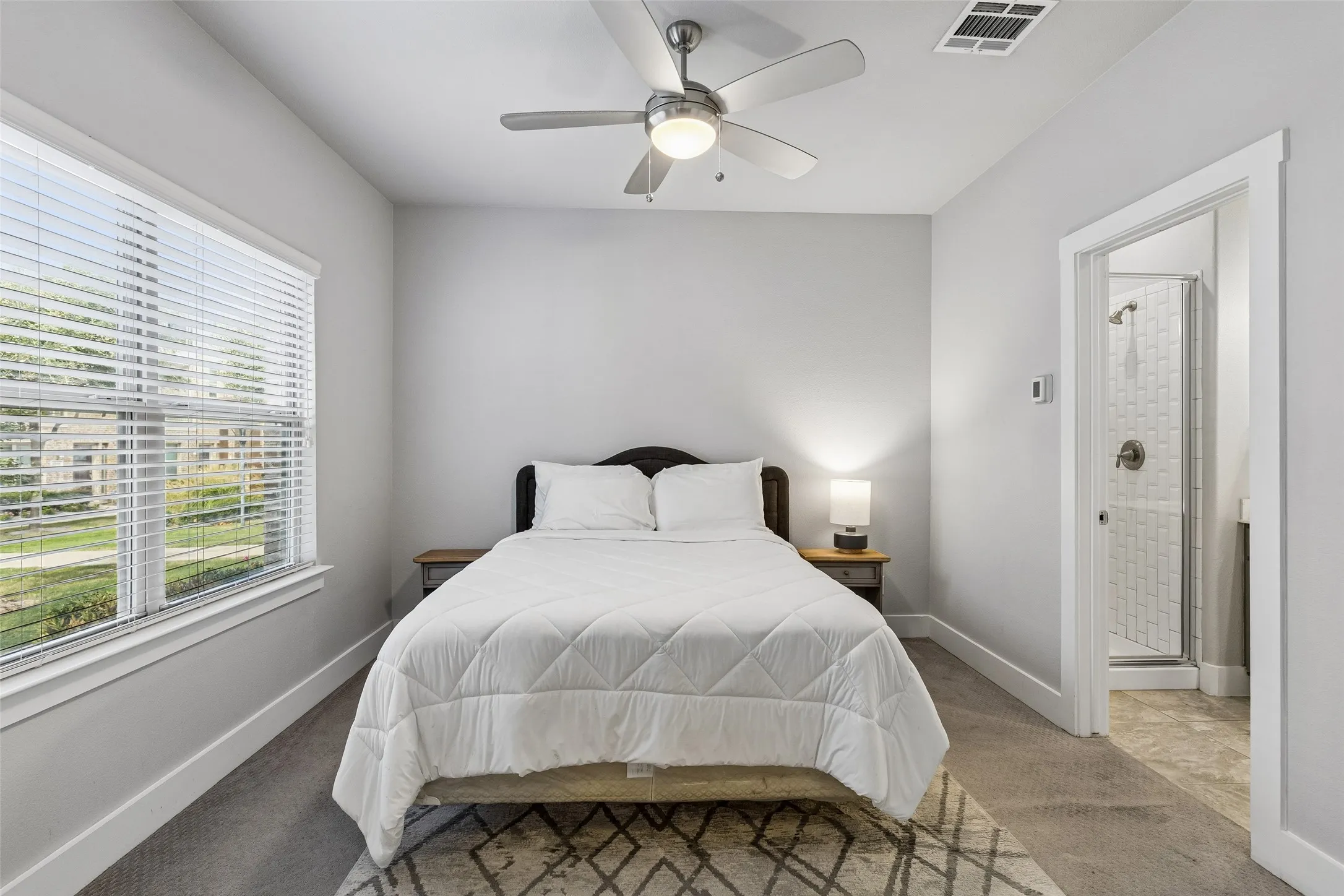Carpeted room featuring a ceiling fan with integrated lighting, a window with blinds, and white trim