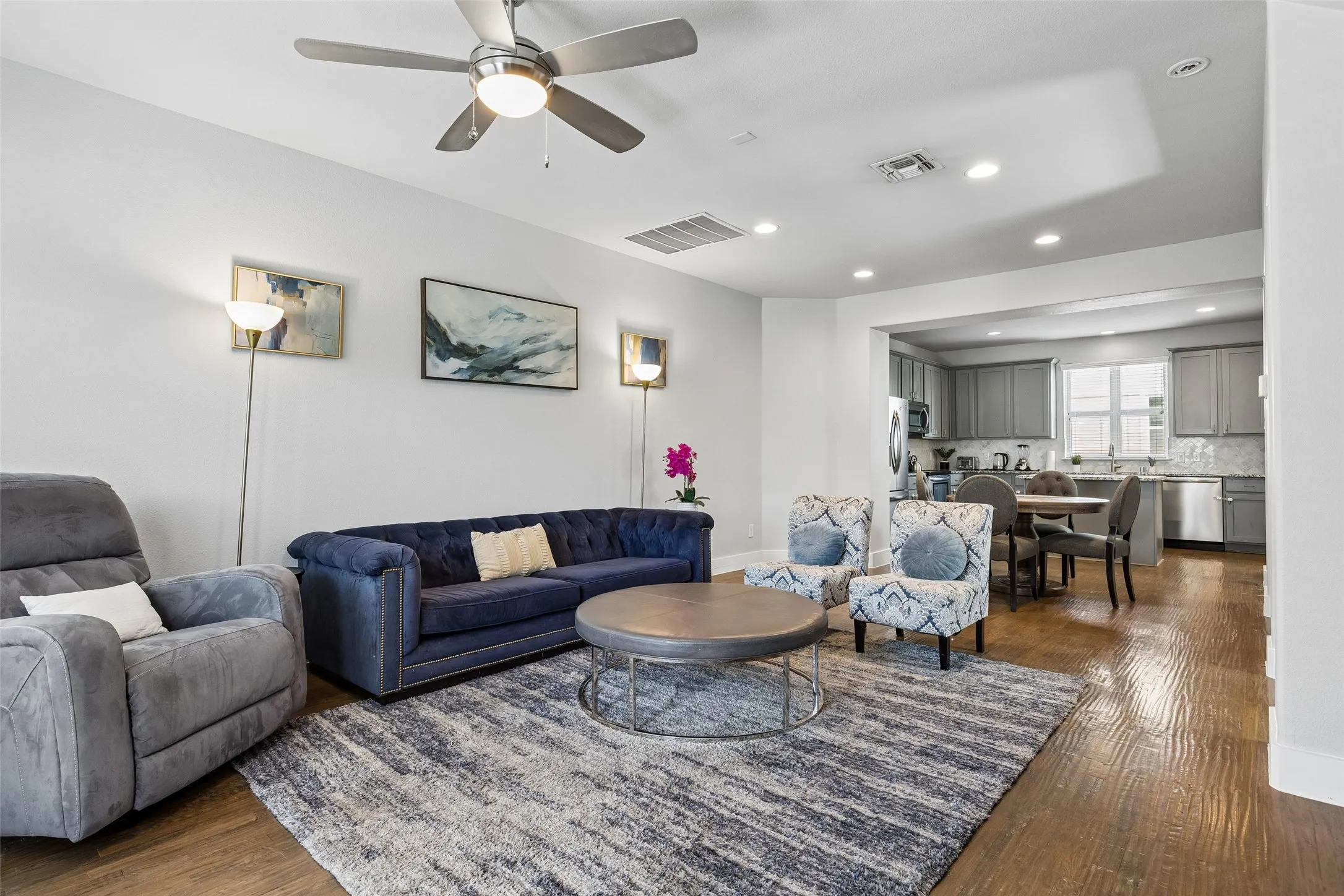 Open-concept living space with recessed lighting, wood-finish flooring, and a ceiling fan