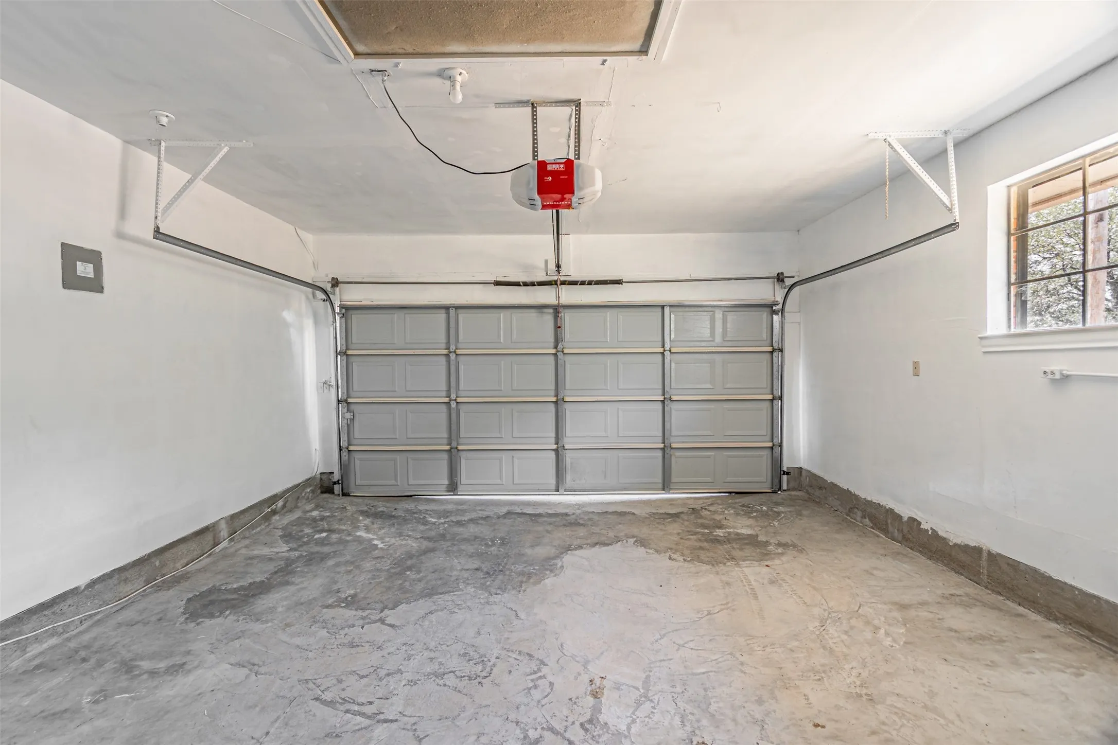 Attached garage with a panel garage door, automatic opener, and a window for natural light