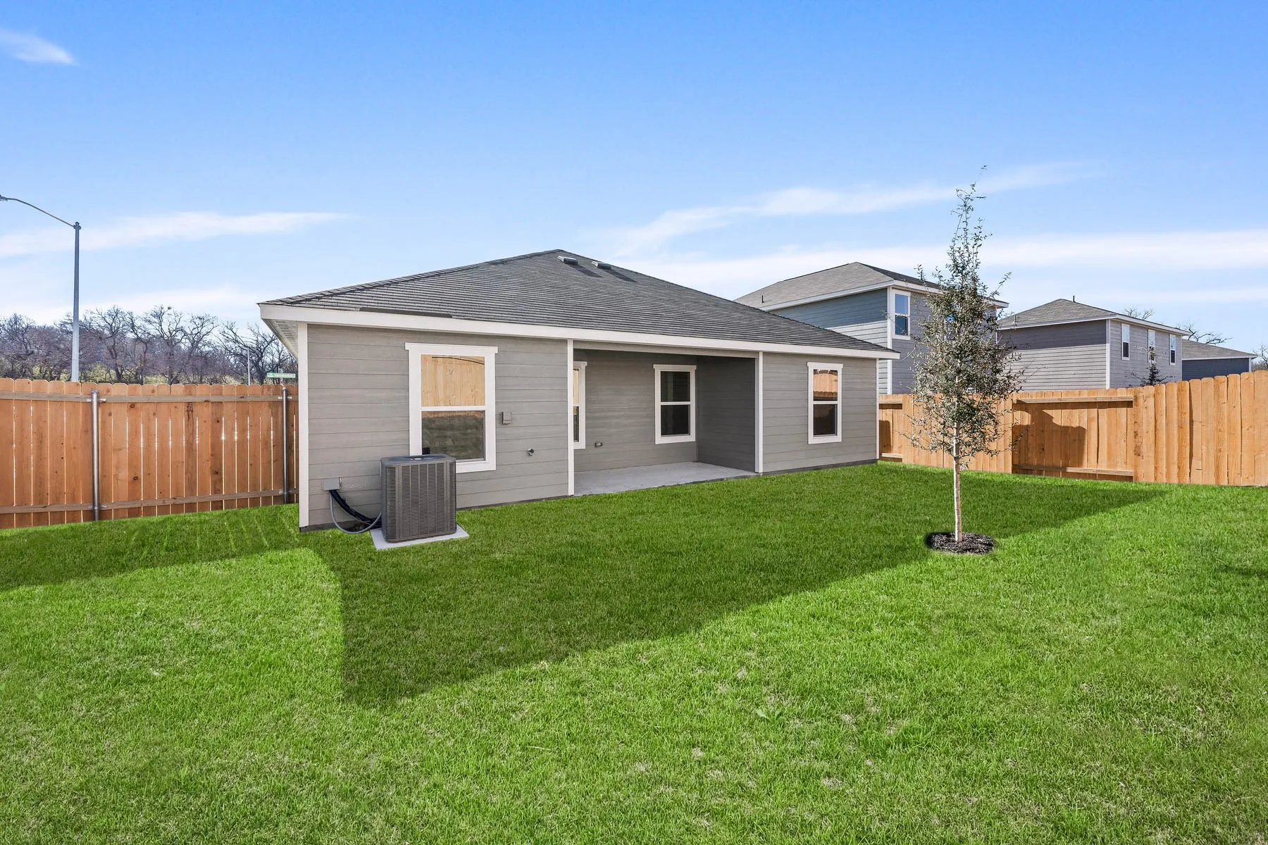 Rear view of house featuring cooling unit, a yard, and a patio