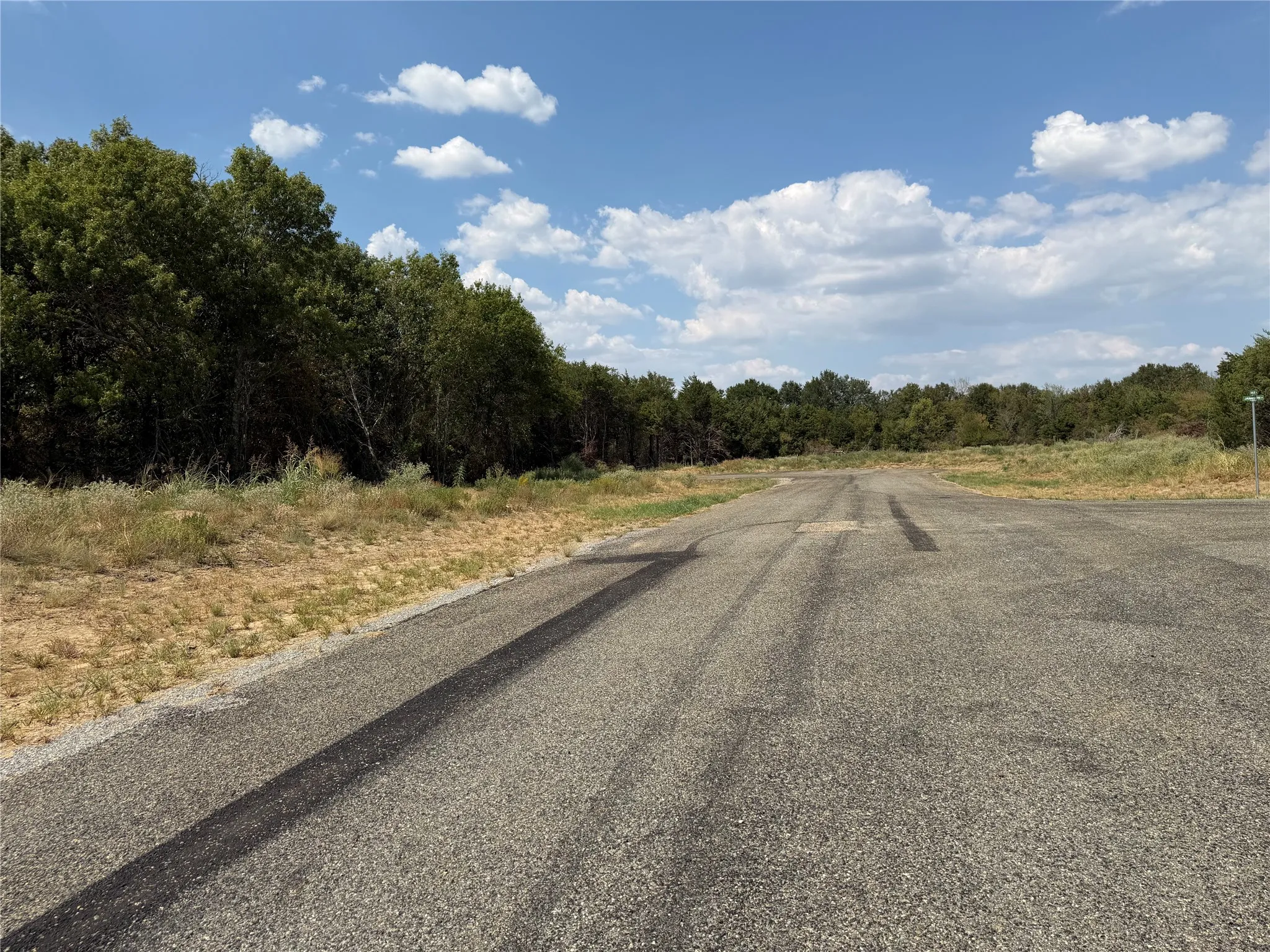 Expansive lot with mature trees and paved access