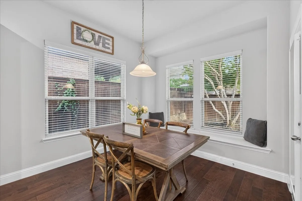 Hardwood-style flooring, multiple windows with blinds, recessed window seating, and a built-in ceiling light fixture