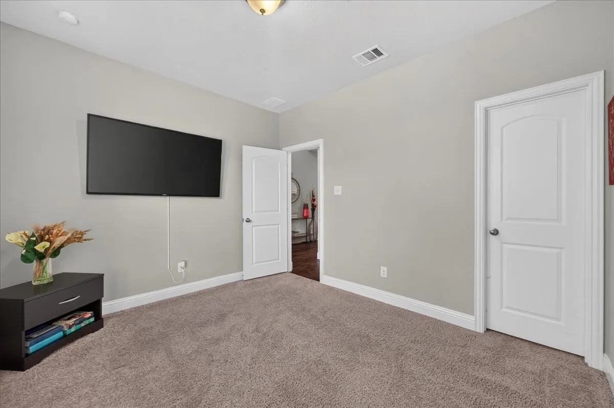 Carpeted flooring, light neutral wall paint, white trim, and a white interior door
