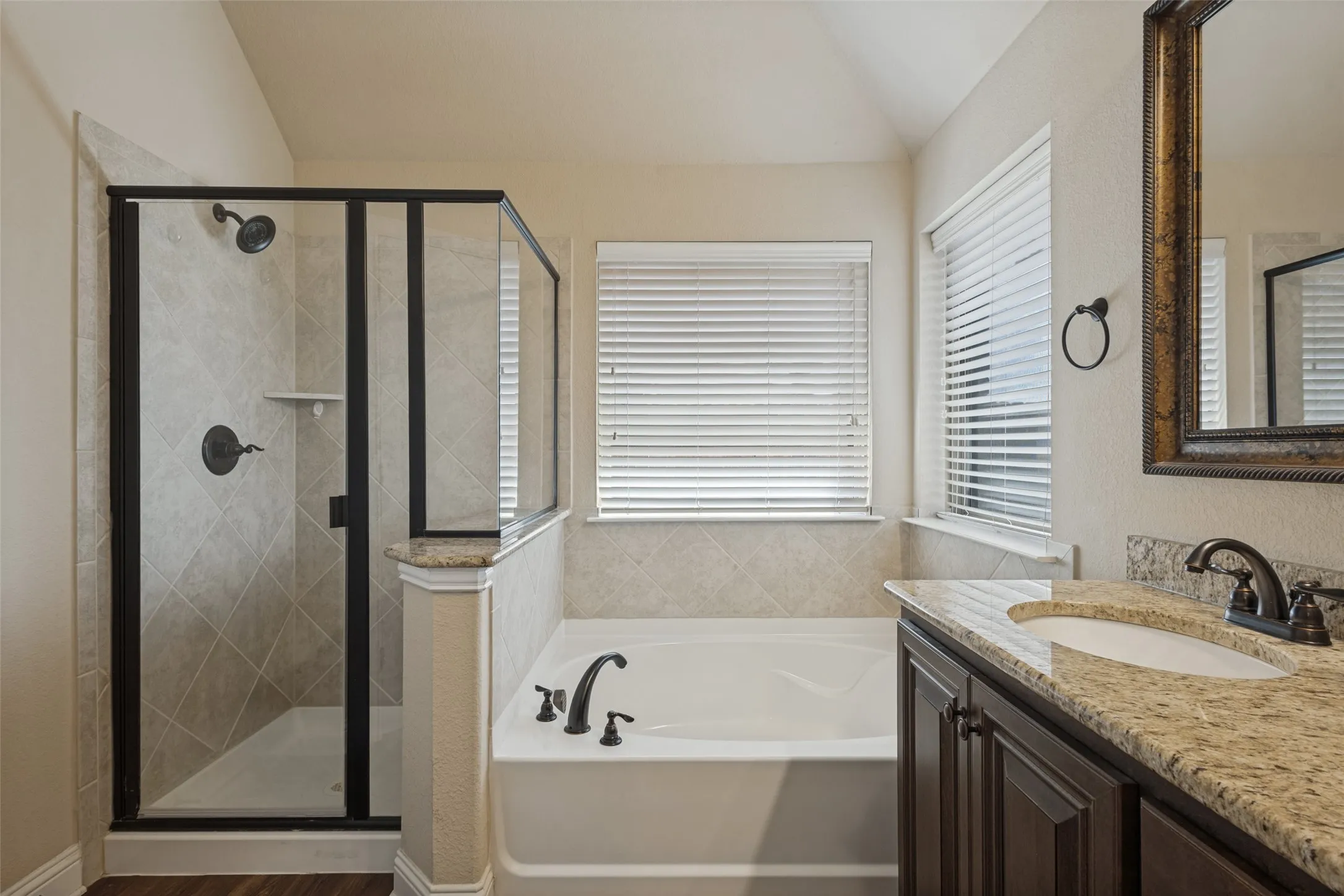 Master bathroom with garden tub and nicely tiled walk in shower.