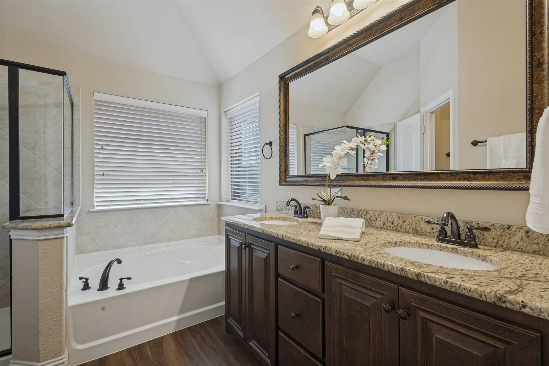 Master bathroom has dual sinks along with decorative mirror and lighting.