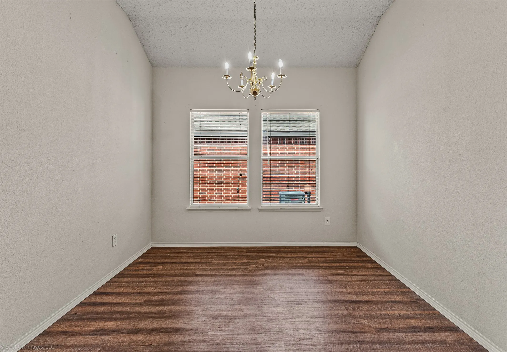Dining room or flex space with LVP flooring and decorative lighting.