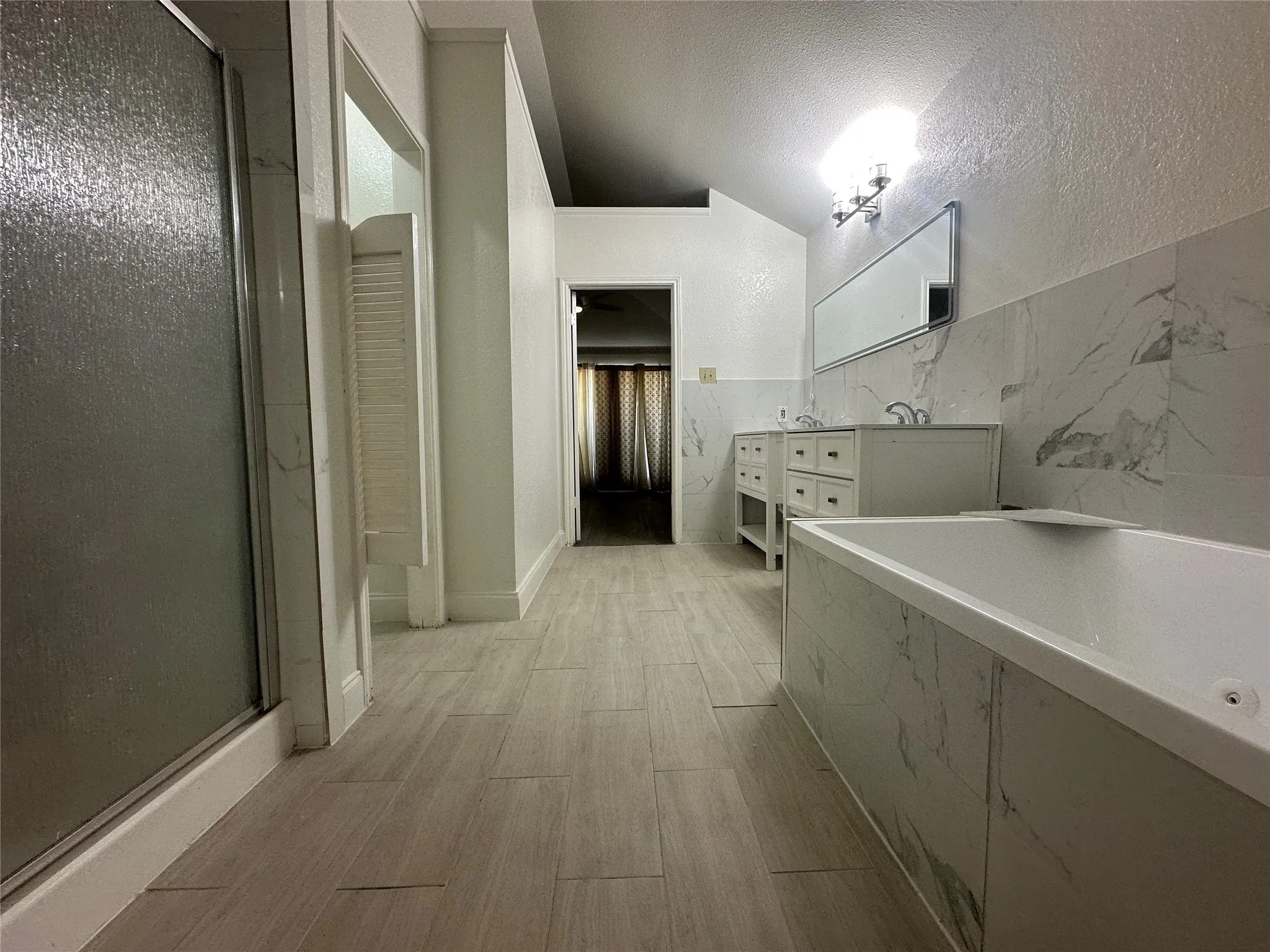 Dual vanity with undermount sinks, integrated soaking tub, and a separate glass-enclosed shower