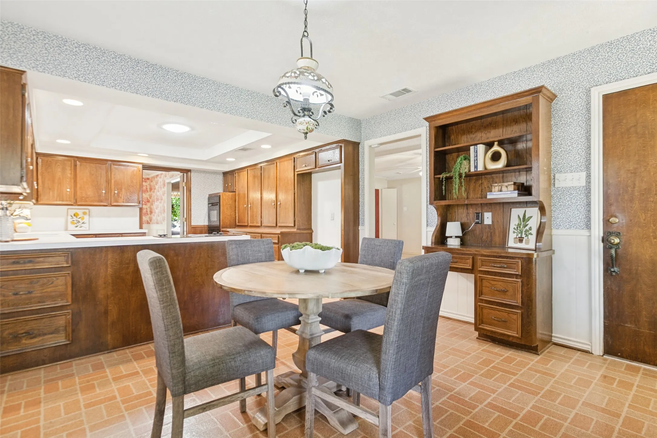 915 Grinnell Dr. - Breakfast area featuring a large windows overlooking the side and backyards, a solid-wood built-in hutch and desk, and convenient access to the covered back porch.