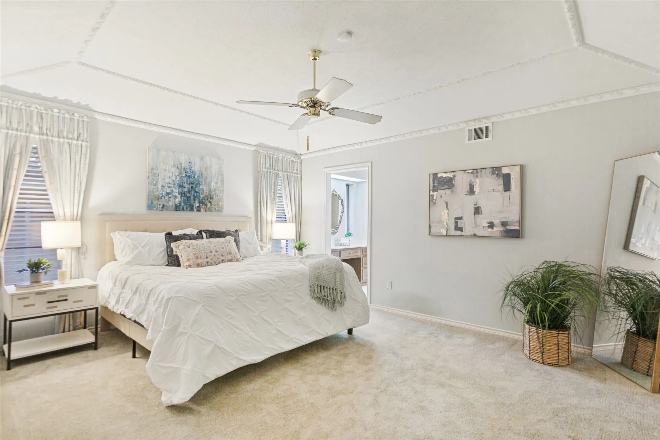 915 Grinnell Dr. - Spacious primary bedroom featuring a gently sloped ceiling with elegant crown molding and a private en-suite bathroom.