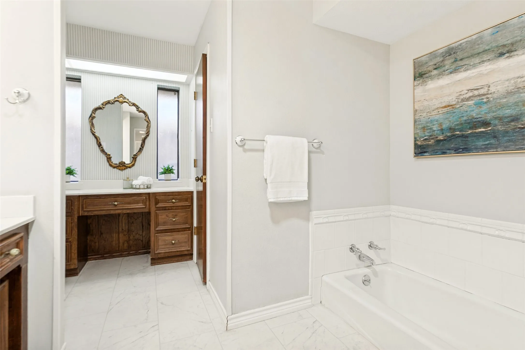 915 Grinnell Dr. - Elegant primary bathroom featuring a sit-down vanity, large dual-sink vanity, sunken soaking tub, separate shower, and access to two spacious walk-in closets.