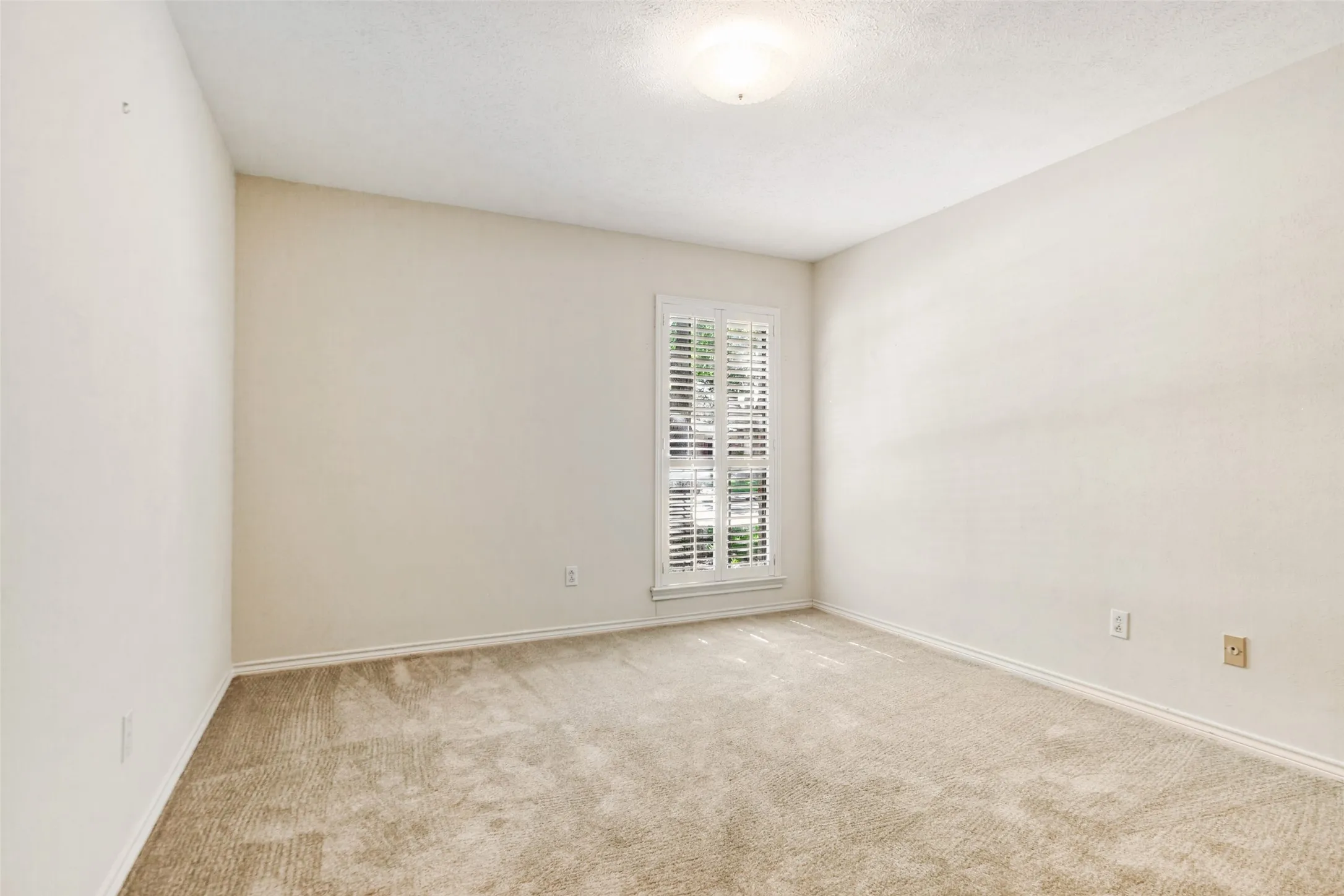 915 Grinnell Dr. - Bedroom featuring a front-facing window with a plantation shutter, providing natural light and a polished architectural detail.
