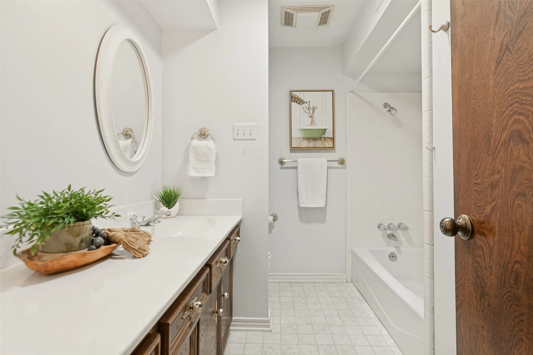 915 Grinnell Dr. - Bathroom featuring a large vanity cabinet with ample storage, single sink, and tub-and-shower combination.