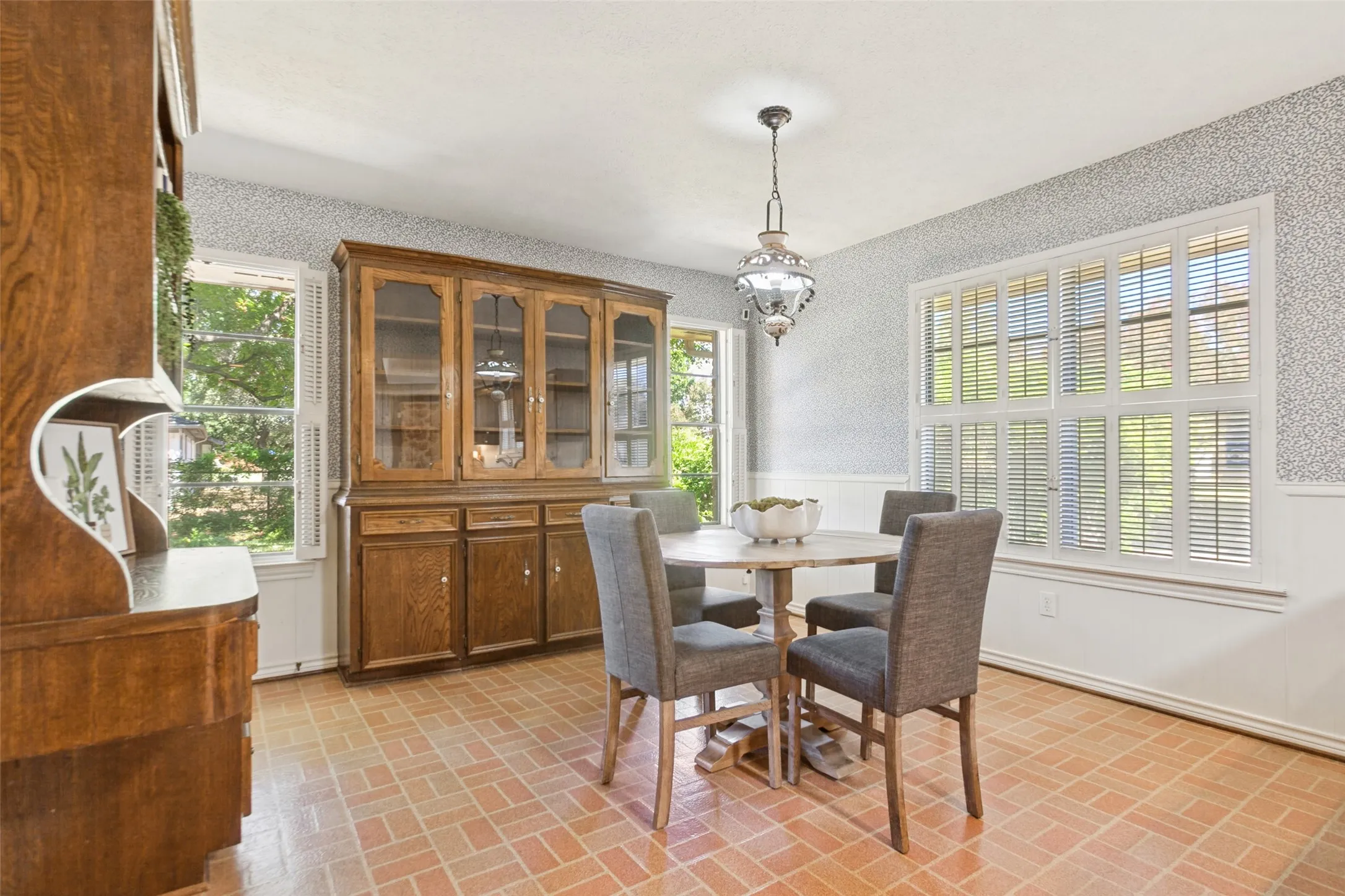 915 Grinnell Dr. - Breakfast area featuring a large windows overlooking the side and backyards, a solid-wood built-in hutch and desk, and convenient access to the covered back porch.