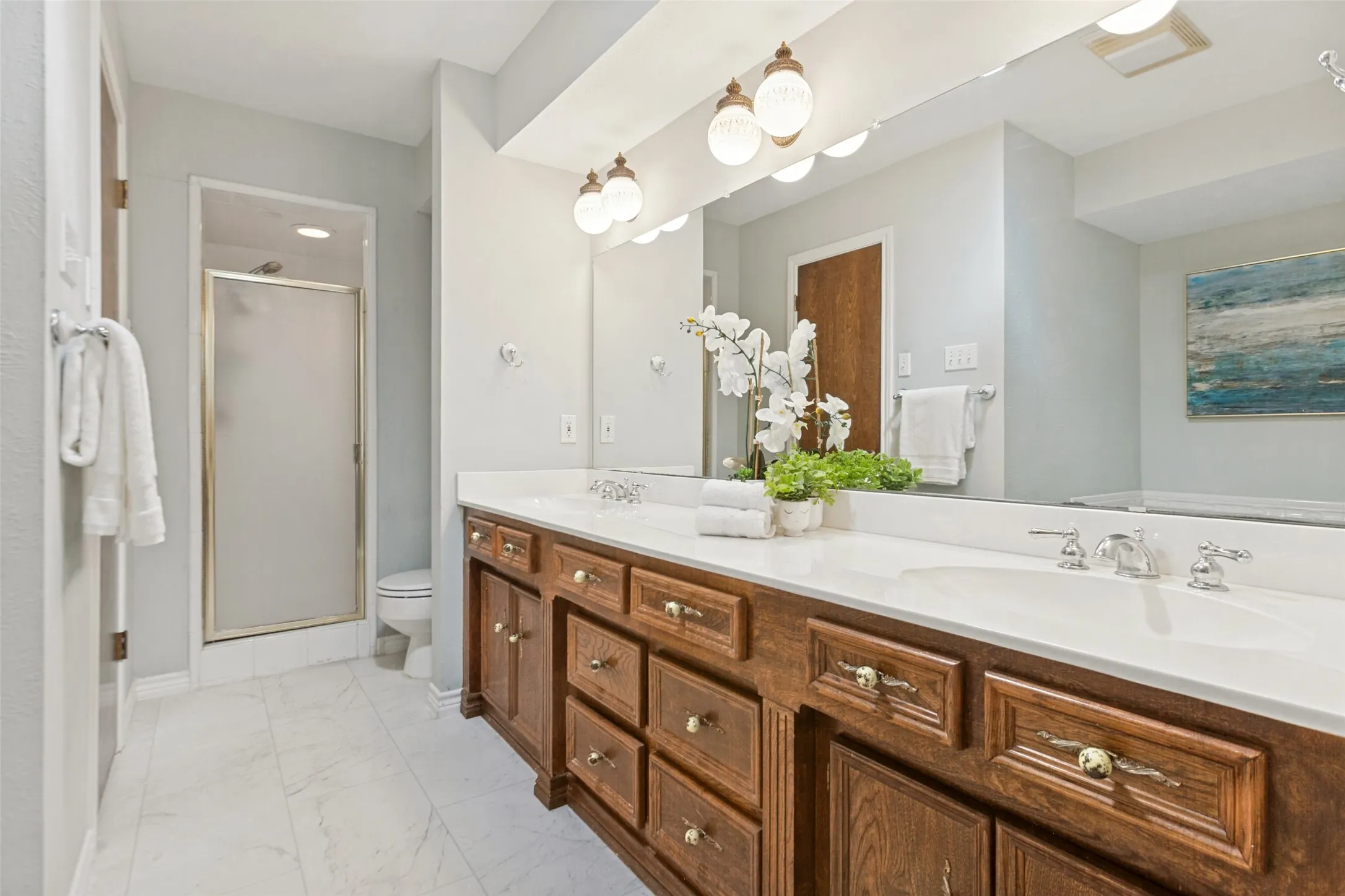 915 Grinnell Dr. - Elegant primary bathroom featuring a sit-down vanity, large dual-sink vanity, sunken soaking tub, separate shower, and access to two spacious walk-in closets.