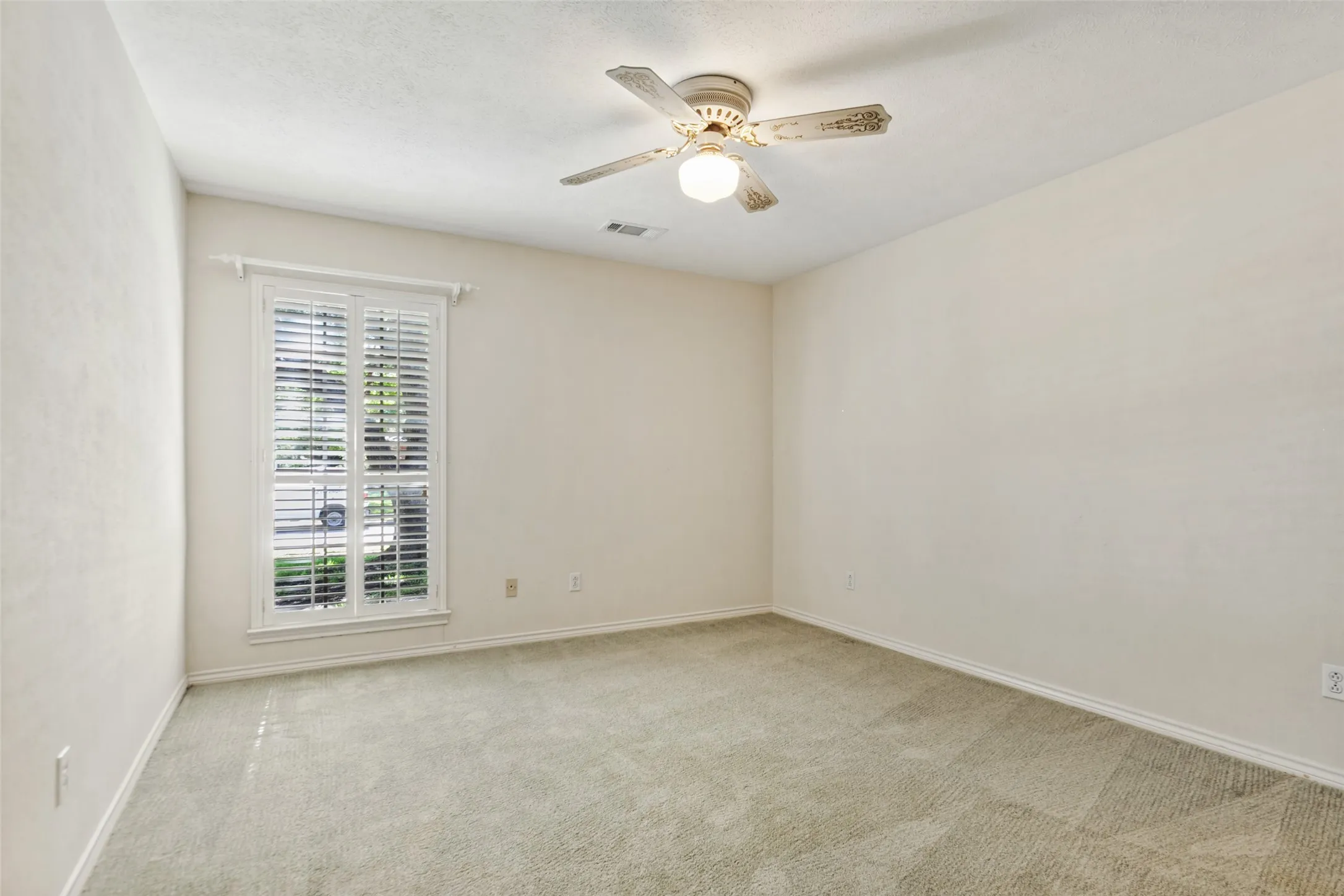 915 Grinnell Dr. - Bedroom featuring a front-facing window with a plantation shutter, providing natural light and a polished architectural detail.
