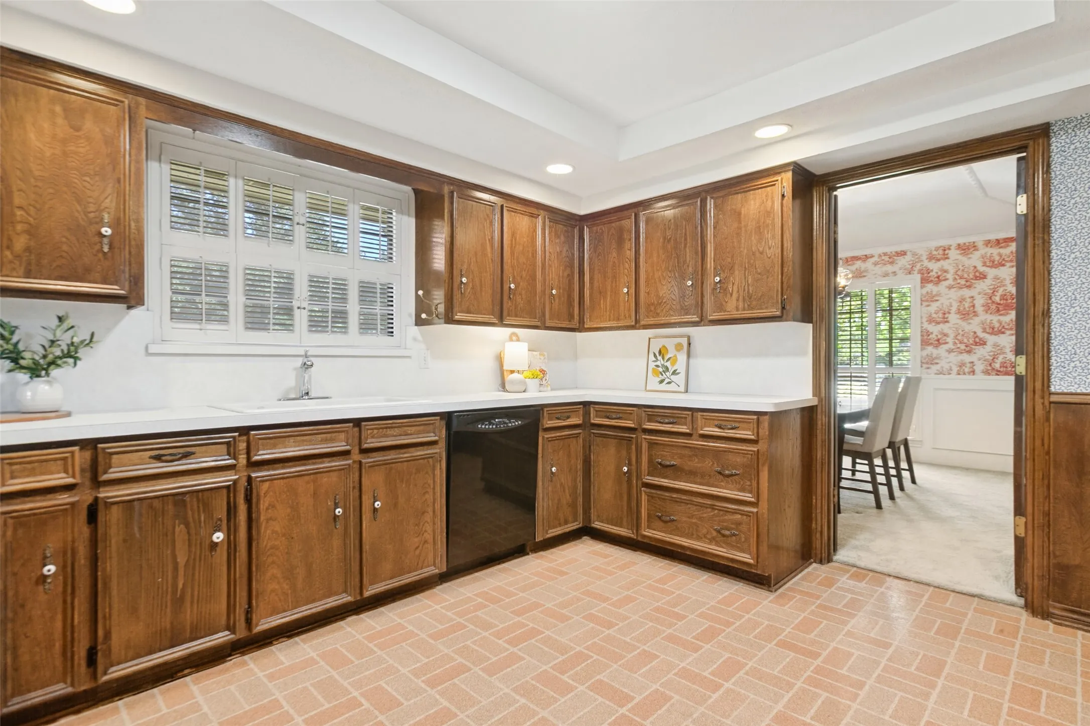 915 Grinnell Dr. - Kitchen featuring a tray ceiling with recessed lighting, a solar tube for additional natural light, traditional wood cabinetry with abundant storage, double ovens, and a large window above the kitchen sink.