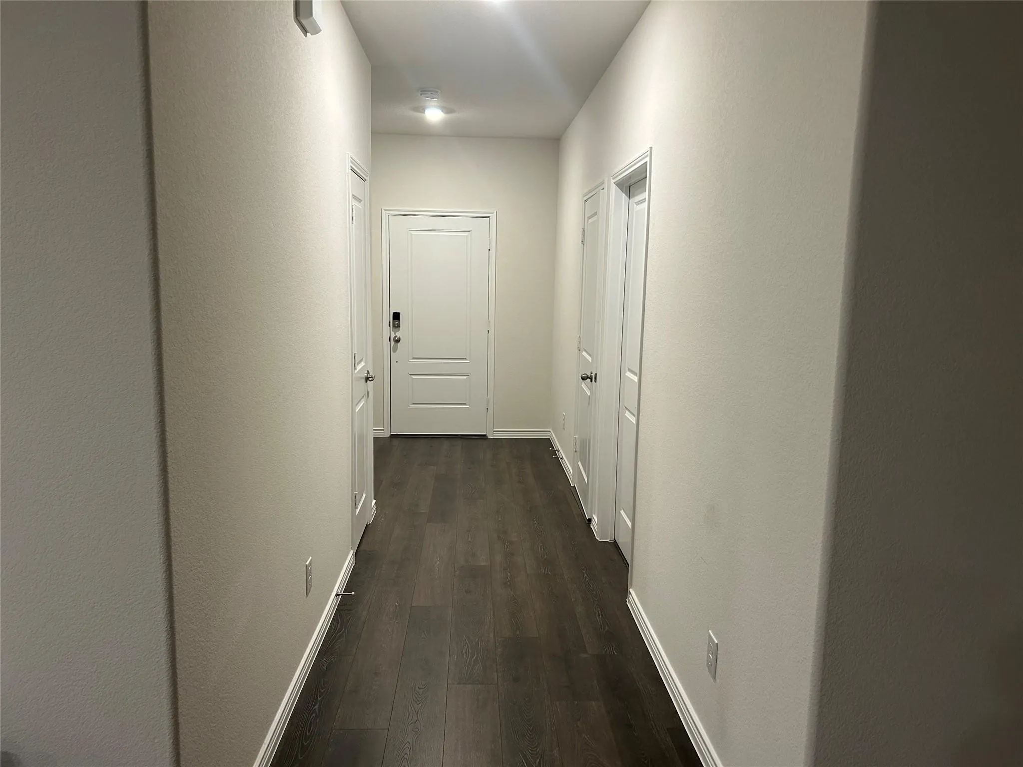 Wood-finish flooring throughout, white interior doors, and recessed ceiling lighting