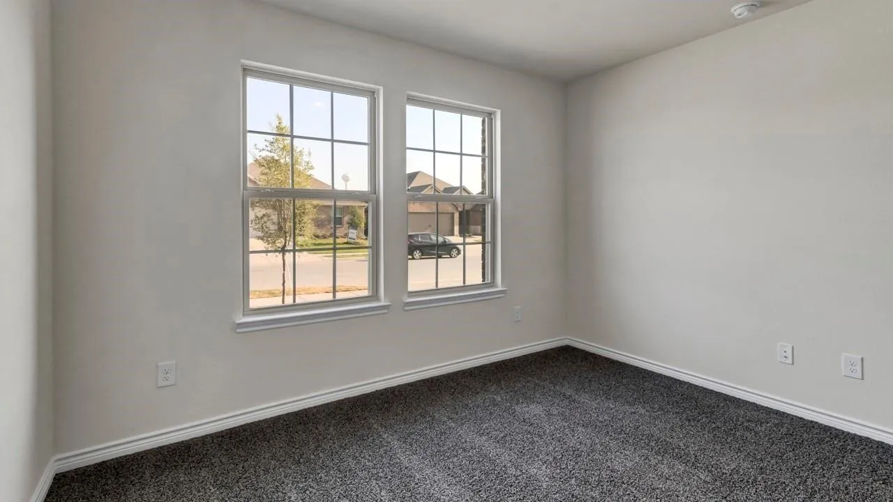 Dual double-hung windows with grid panes, wall-to-wall carpeting, and neutral wall finishes