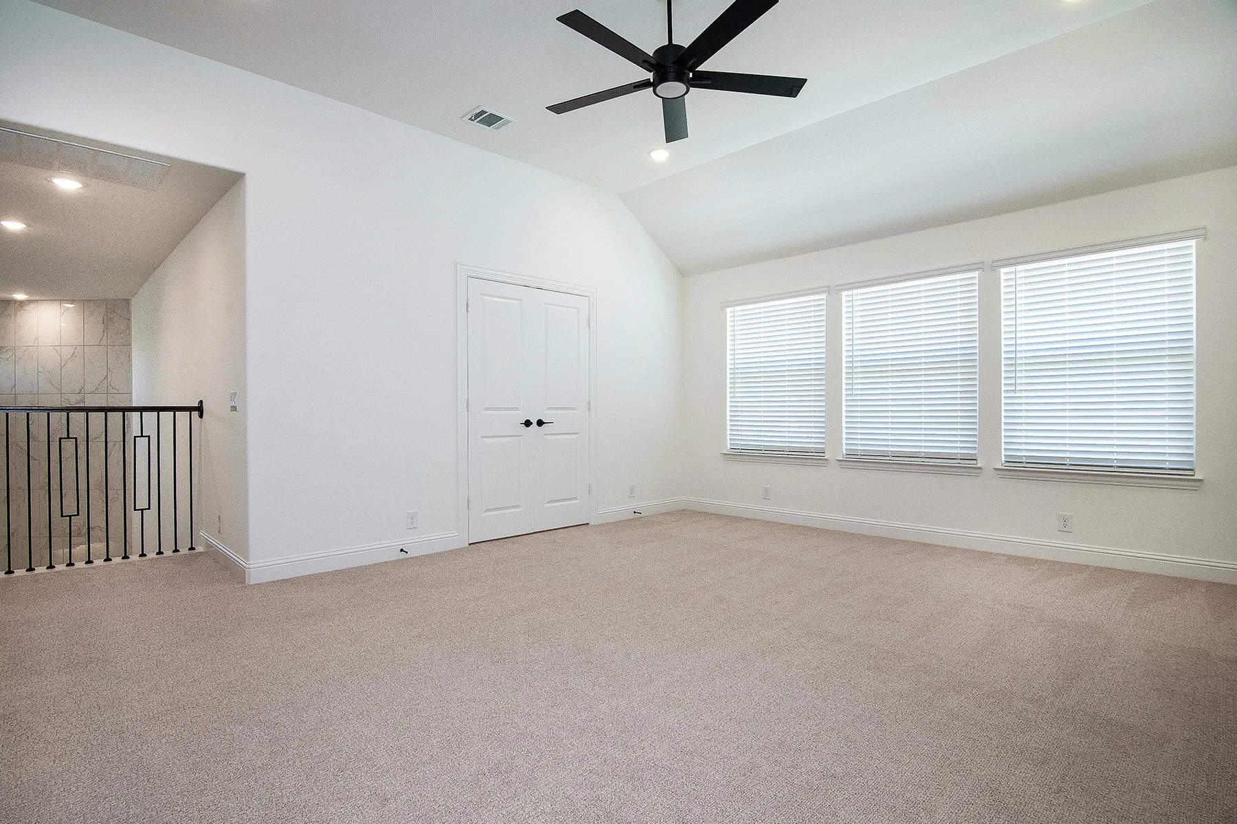 Vaulted ceiling with recessed lighting and a ceiling fan