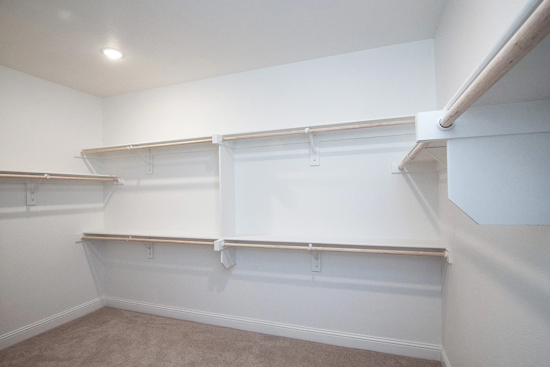 Walk-in closet with recessed lighting, integrated shelving, and hanging rods