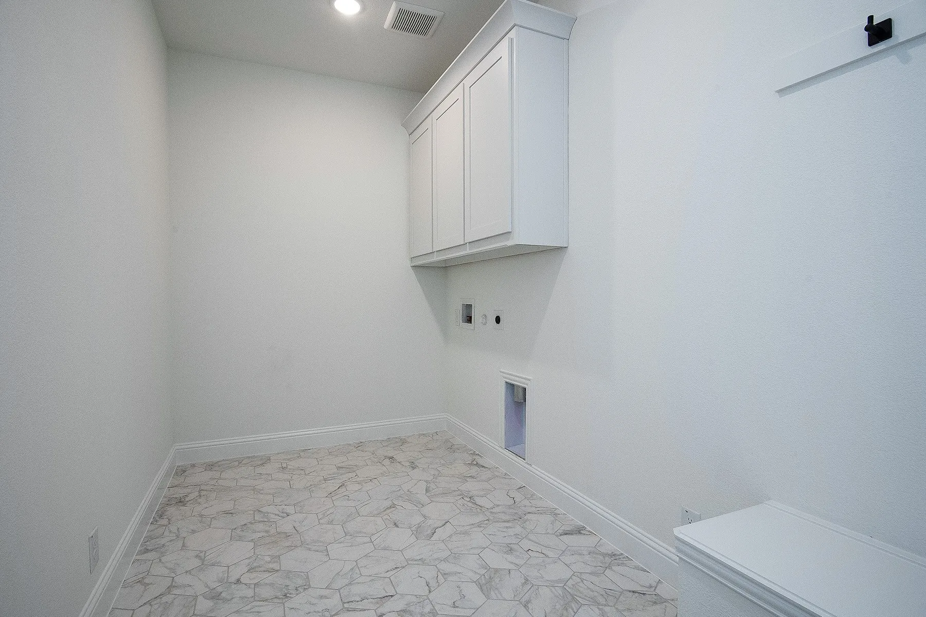 White shaker-style cabinetry with crown molding