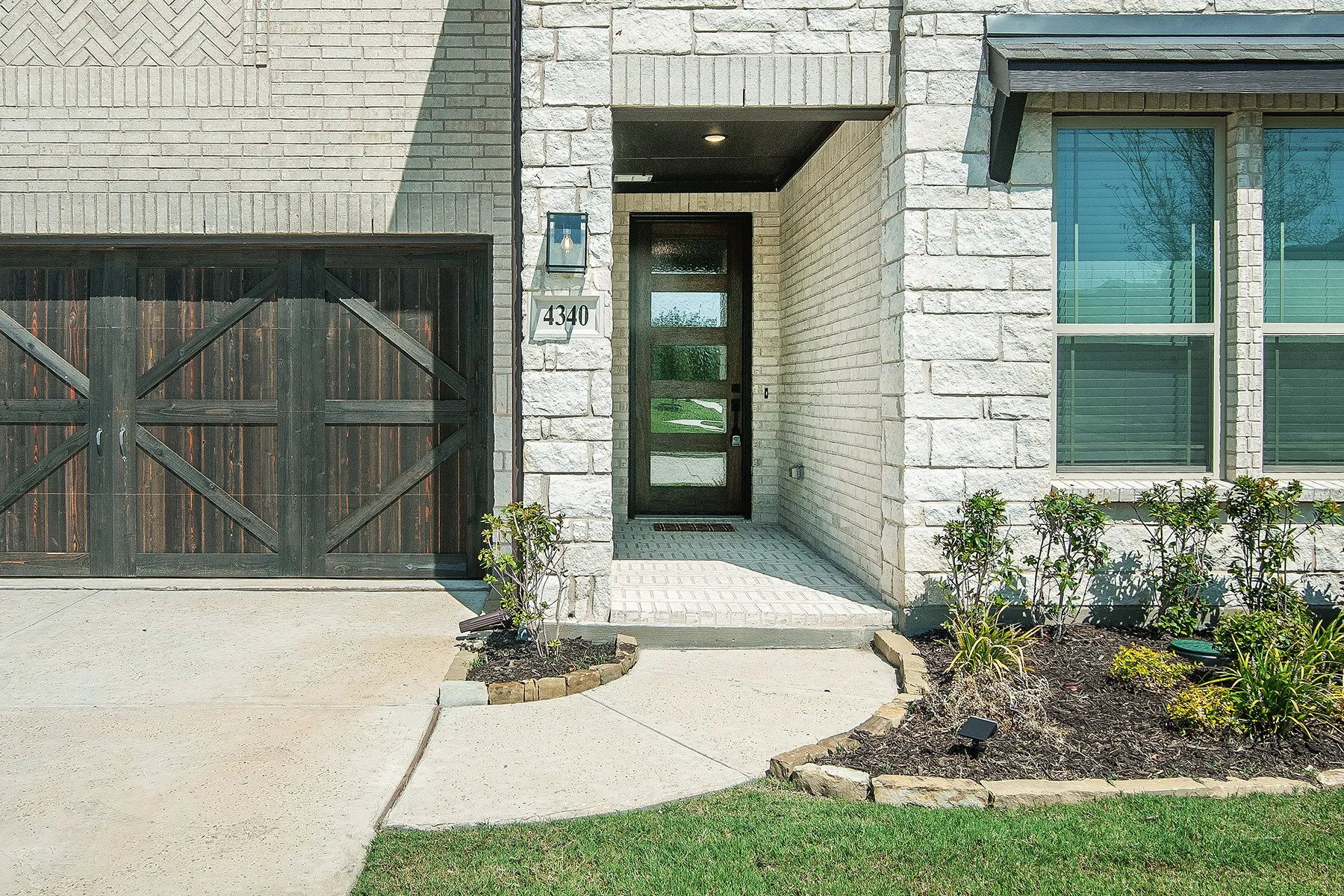 Stone and brick facade with a wood-finish garage door