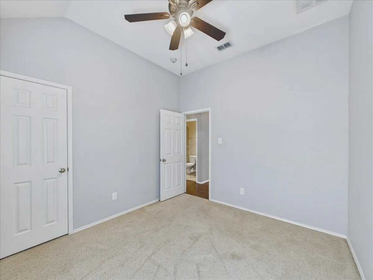 Carpeted room with a ceiling fan, light gray walls, and white trim