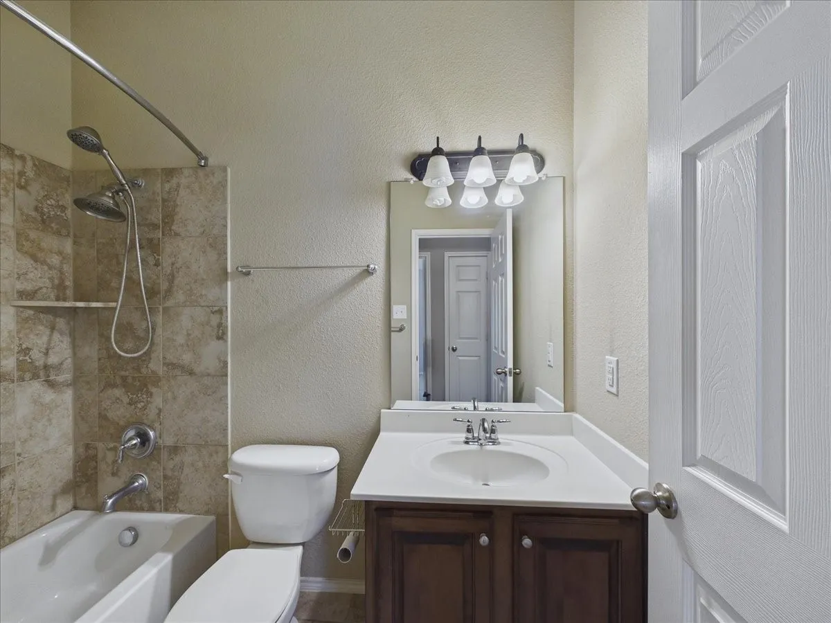 Tub and shower combination with tiled surround and built-in shelf