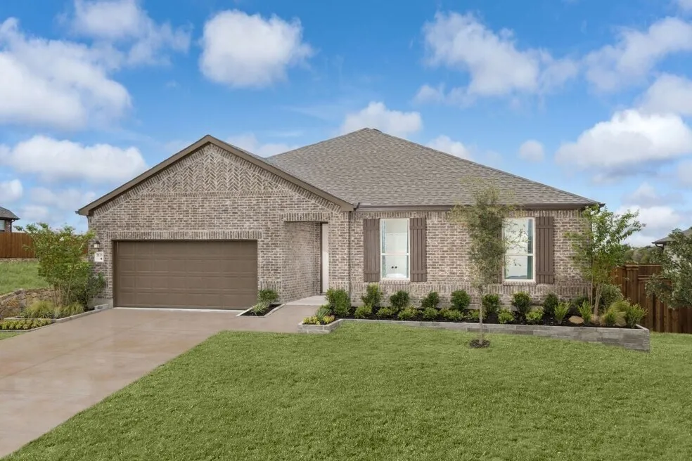Brick exterior with decorative gables, attached garage, and mature landscaping
