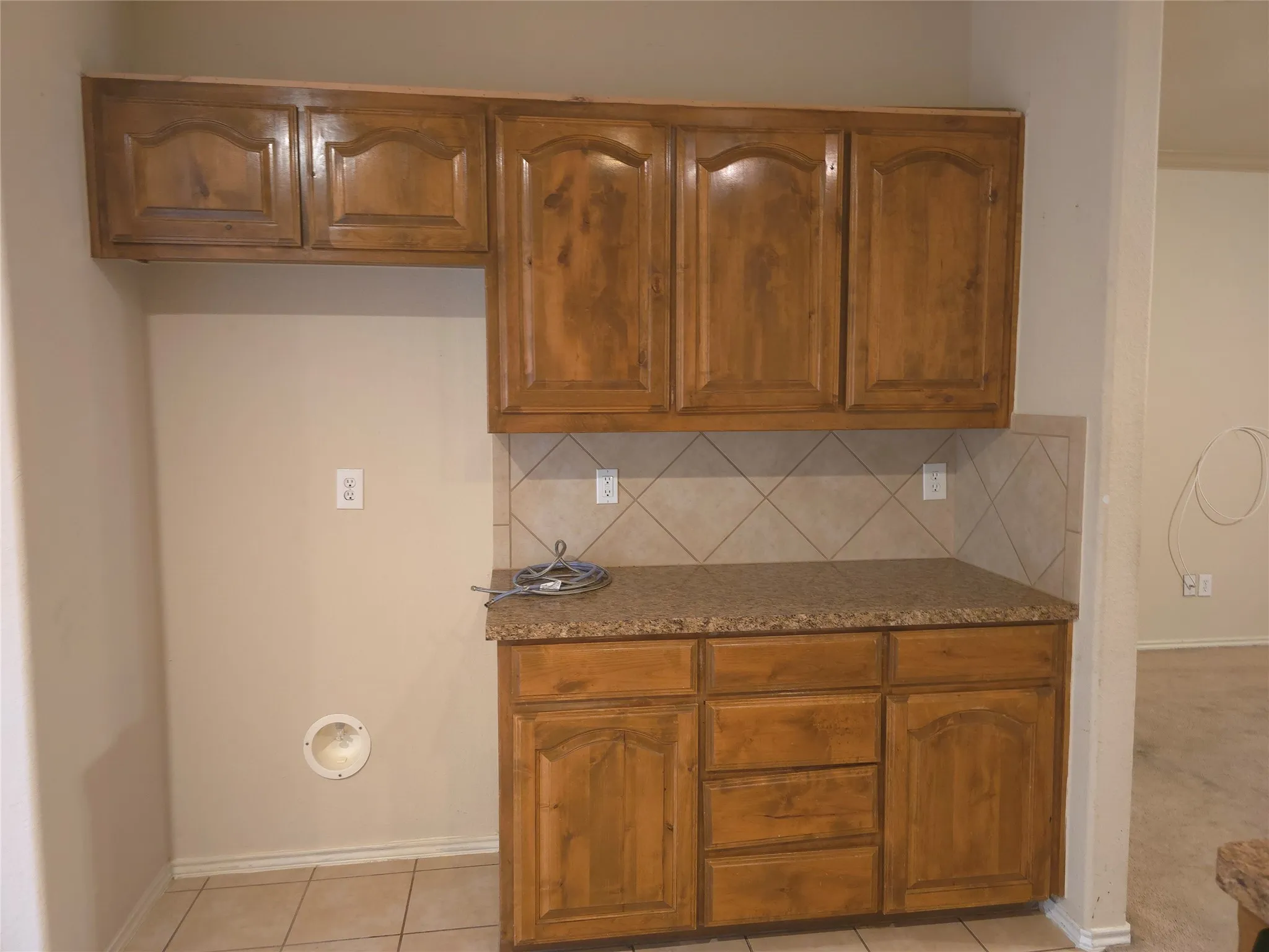 Wood-finish cabinetry with a stone-finish countertop