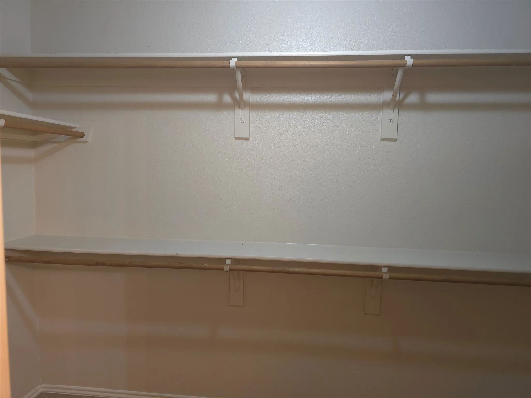 Built-in shelving and hanging rods with white wall supports