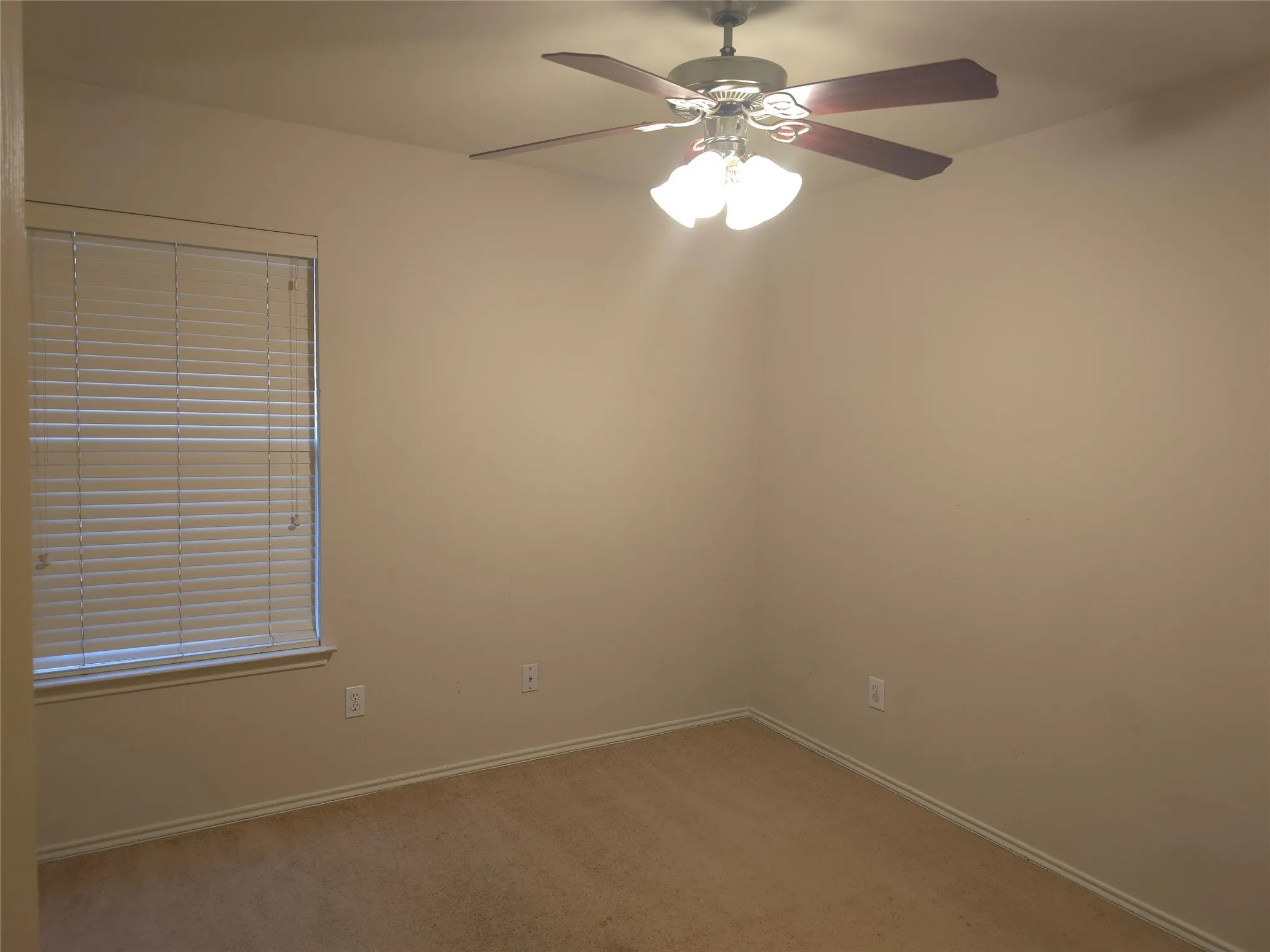 Wall-to-wall carpeting, window with horizontal blinds, and a ceiling fan with integrated lighting