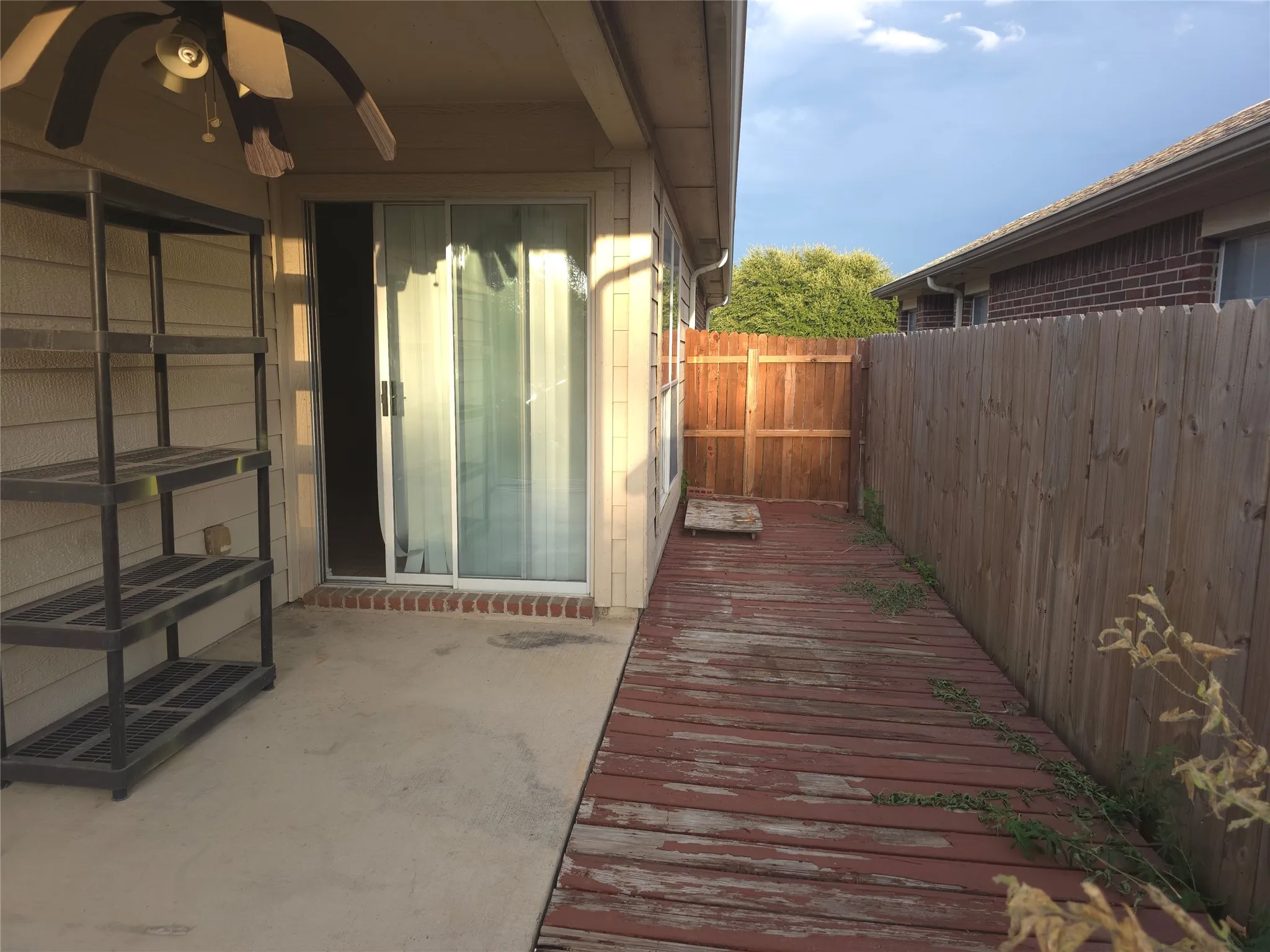 Concrete patio with a wood-finish deck, enclosed by a wooden fence