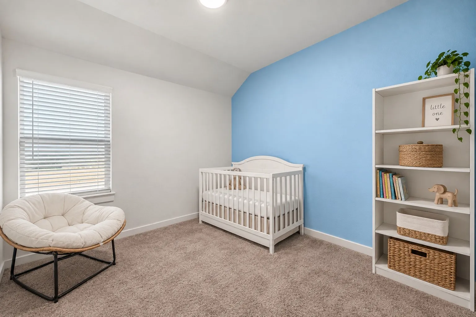 Carpeted flooring, white trim, single window with horizontal blinds, built-in shelving, and a prominent accent wall