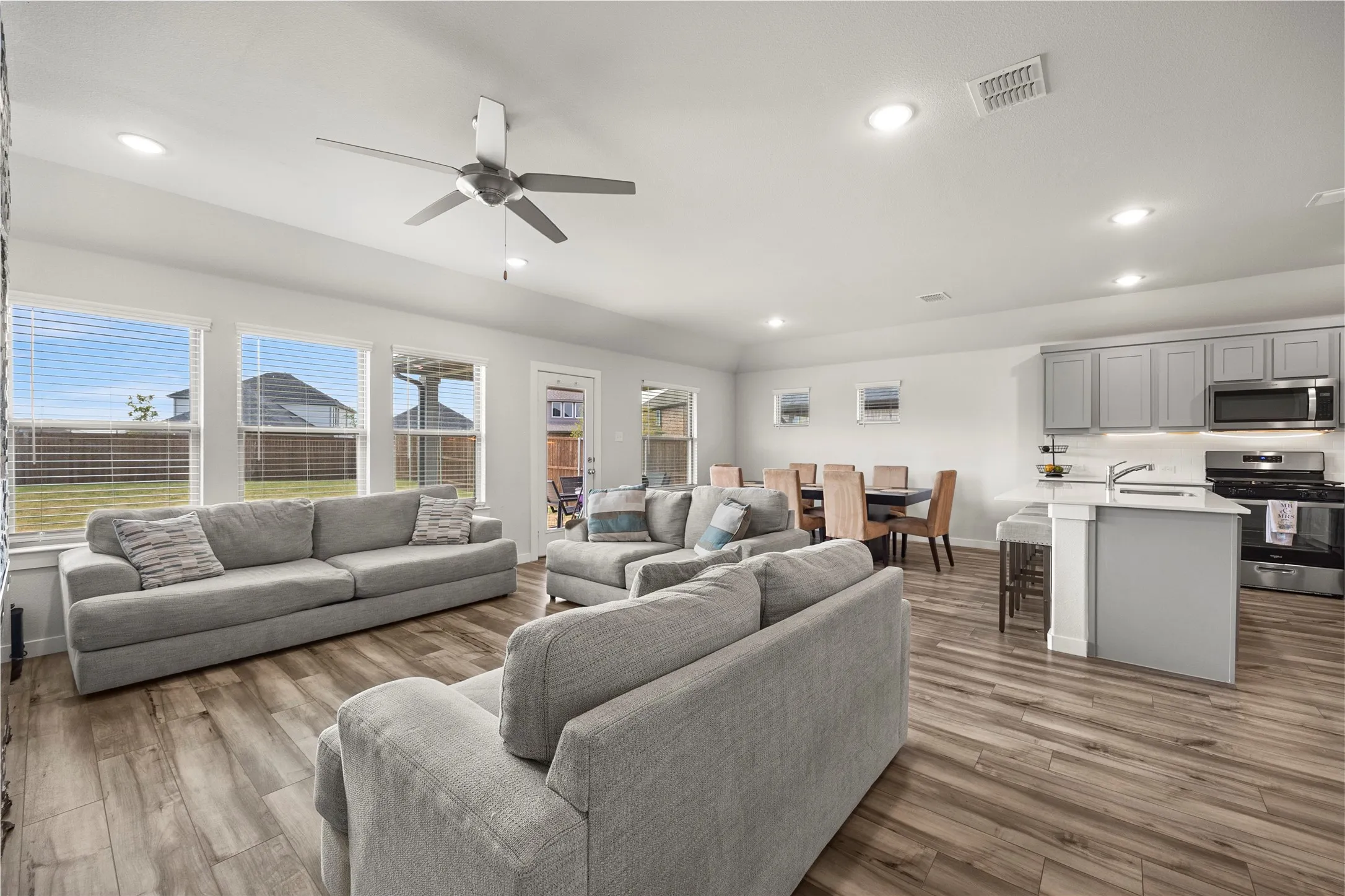 Open-concept layout featuring wood-finish flooring, recessed lighting, and a ceiling fan